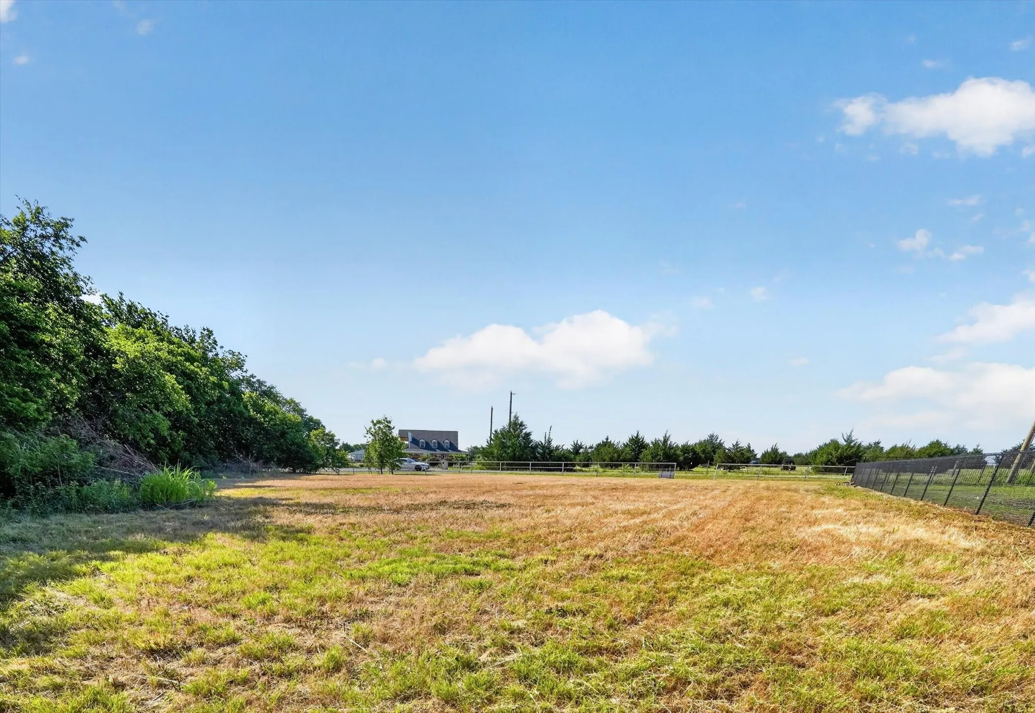 Expansive cleared land parcel with a partial perimeter fence
