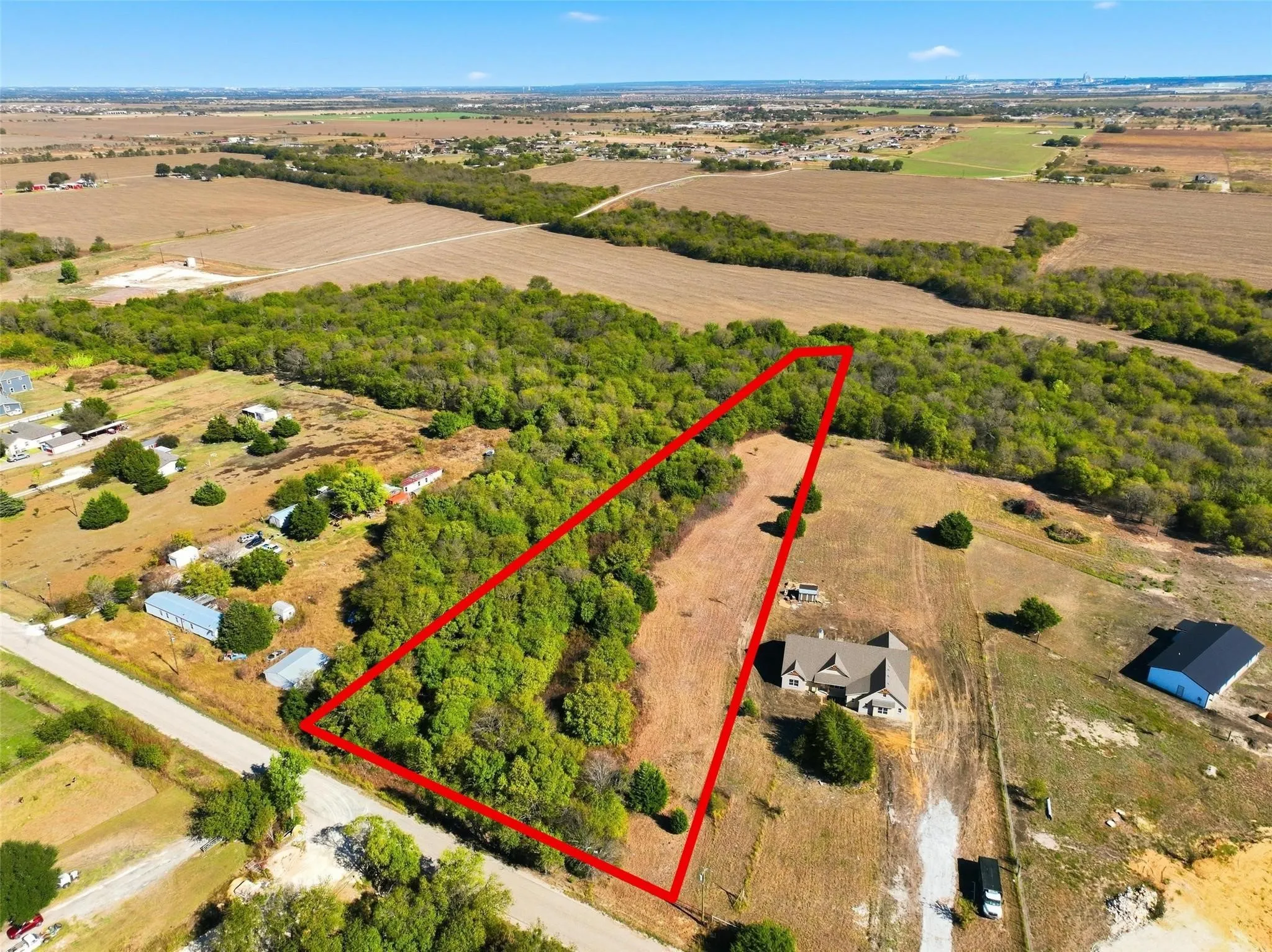 Expansive undeveloped land featuring a mix of mature trees and open fields