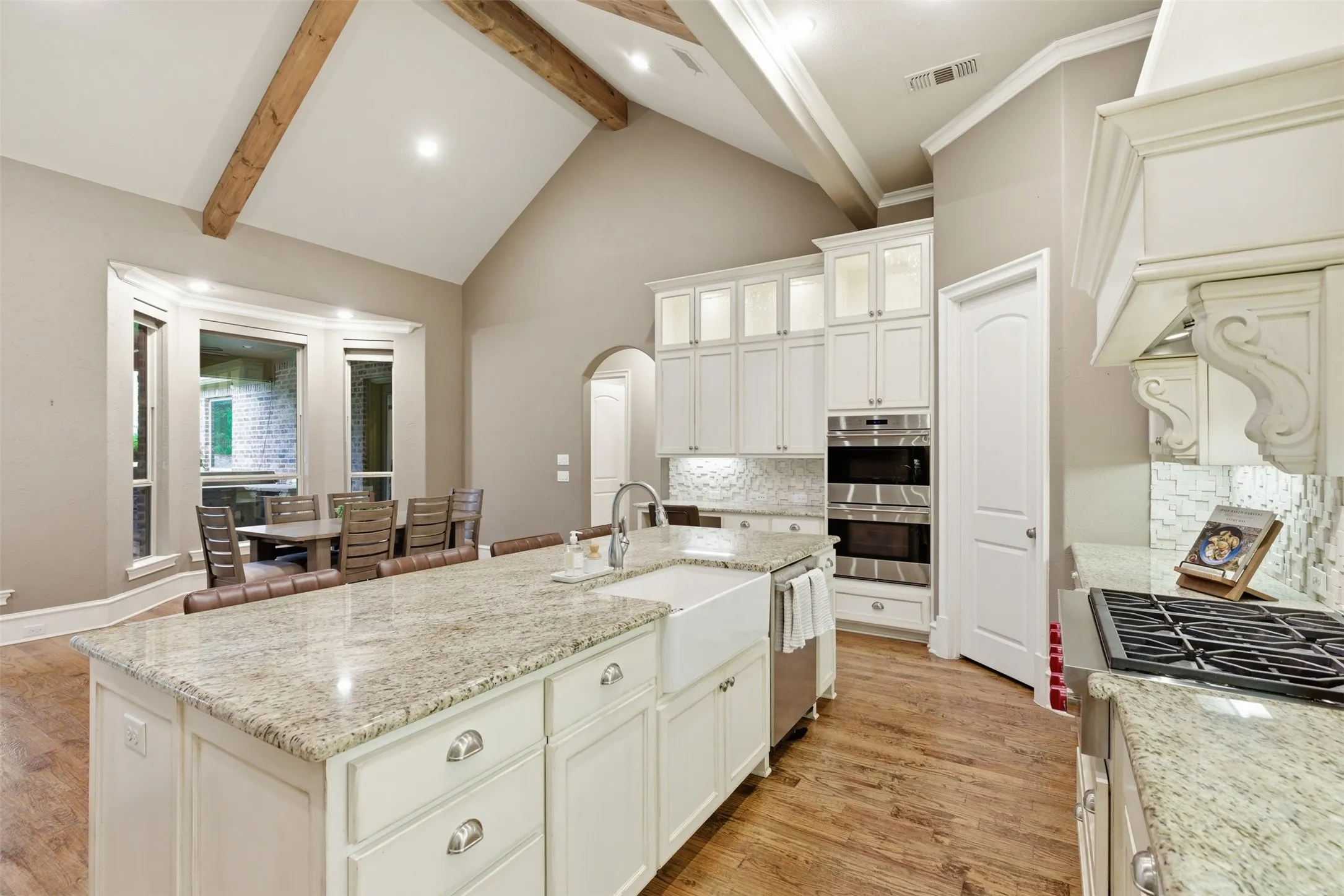 Kitchen featuring a large island with granite countertop, farmhouse sink, and breakfast bar seating