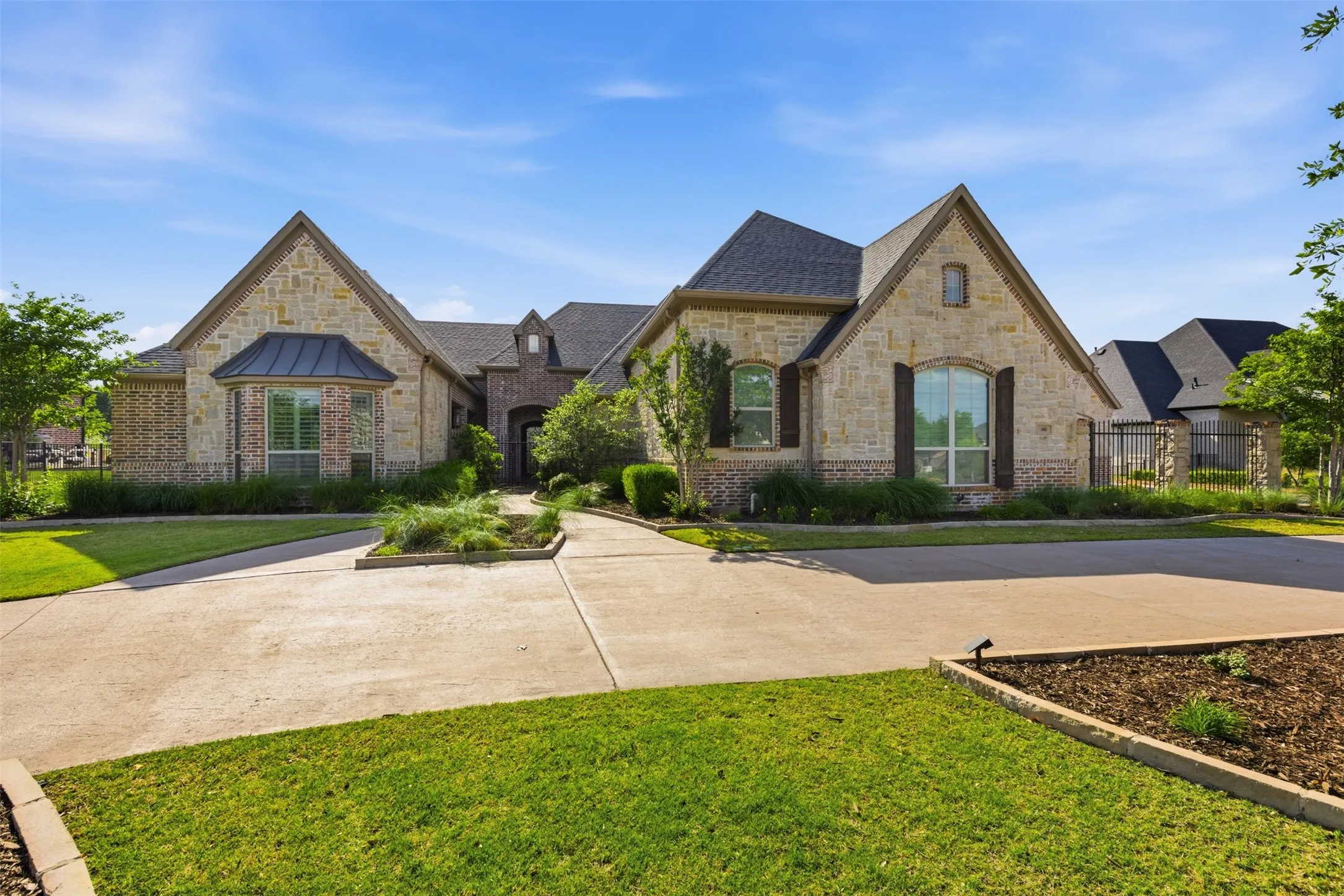 Stone and brick exterior featuring multiple gables and a dark shingle roof