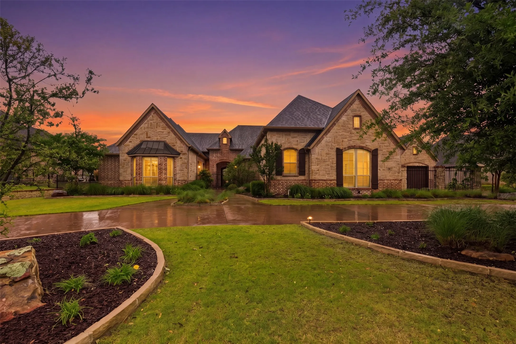 Stone and brick exterior residence featuring a gabled roofline and dark shingle roofing