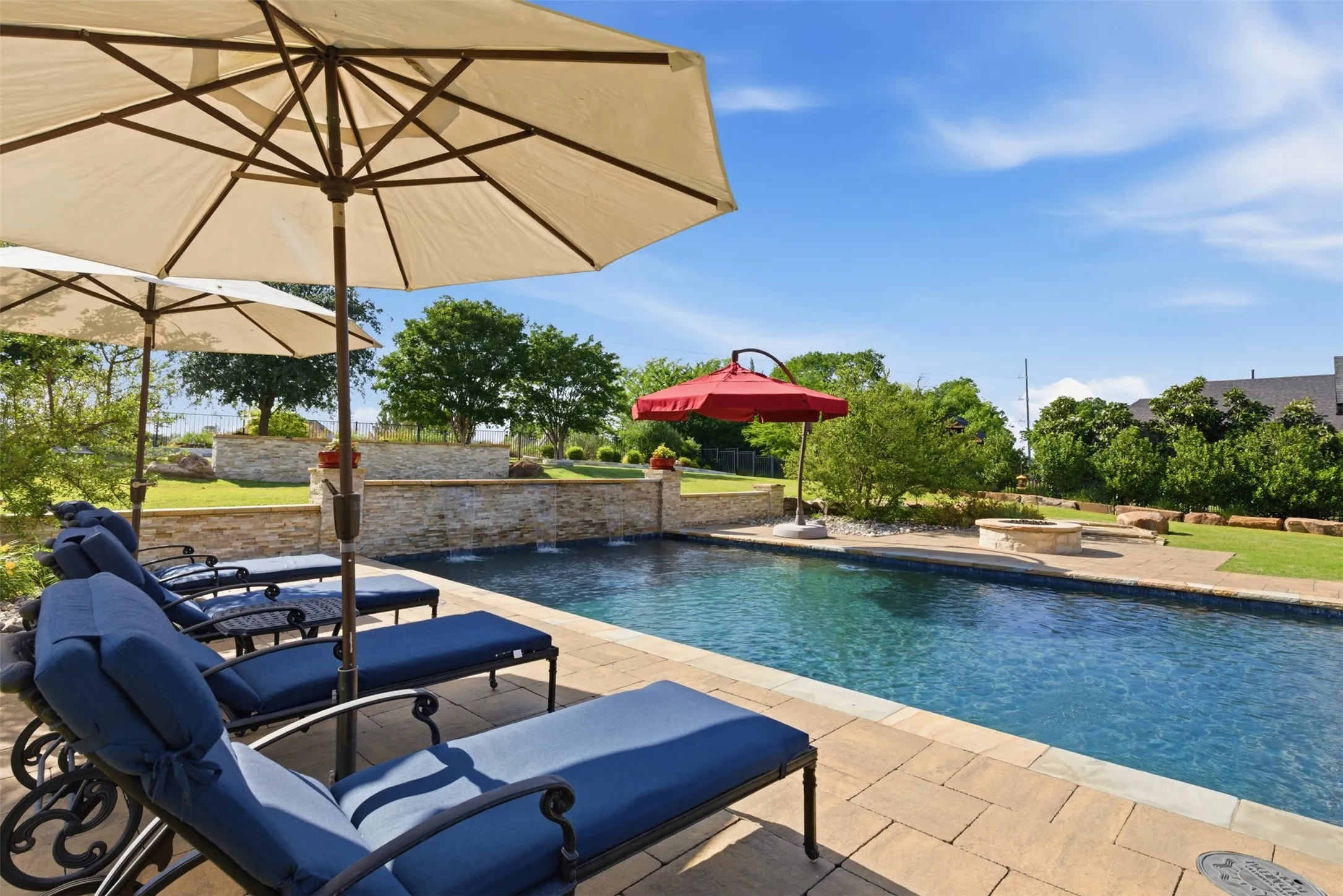 In-ground swimming pool with a stone coping and a paved patio surround