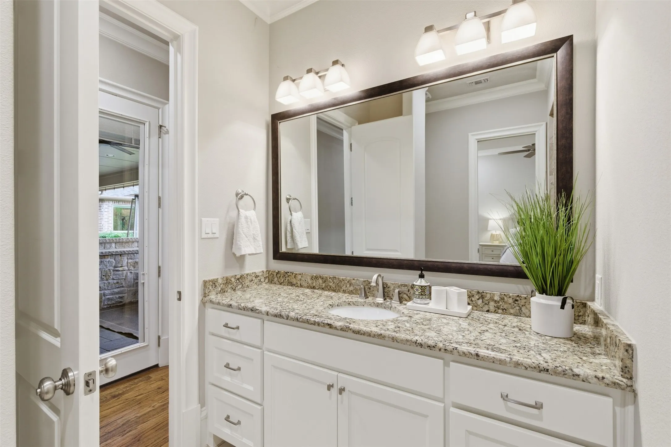 Bathroom vanity featuring a light-toned countertop, an undermount sink, and white cabinetry