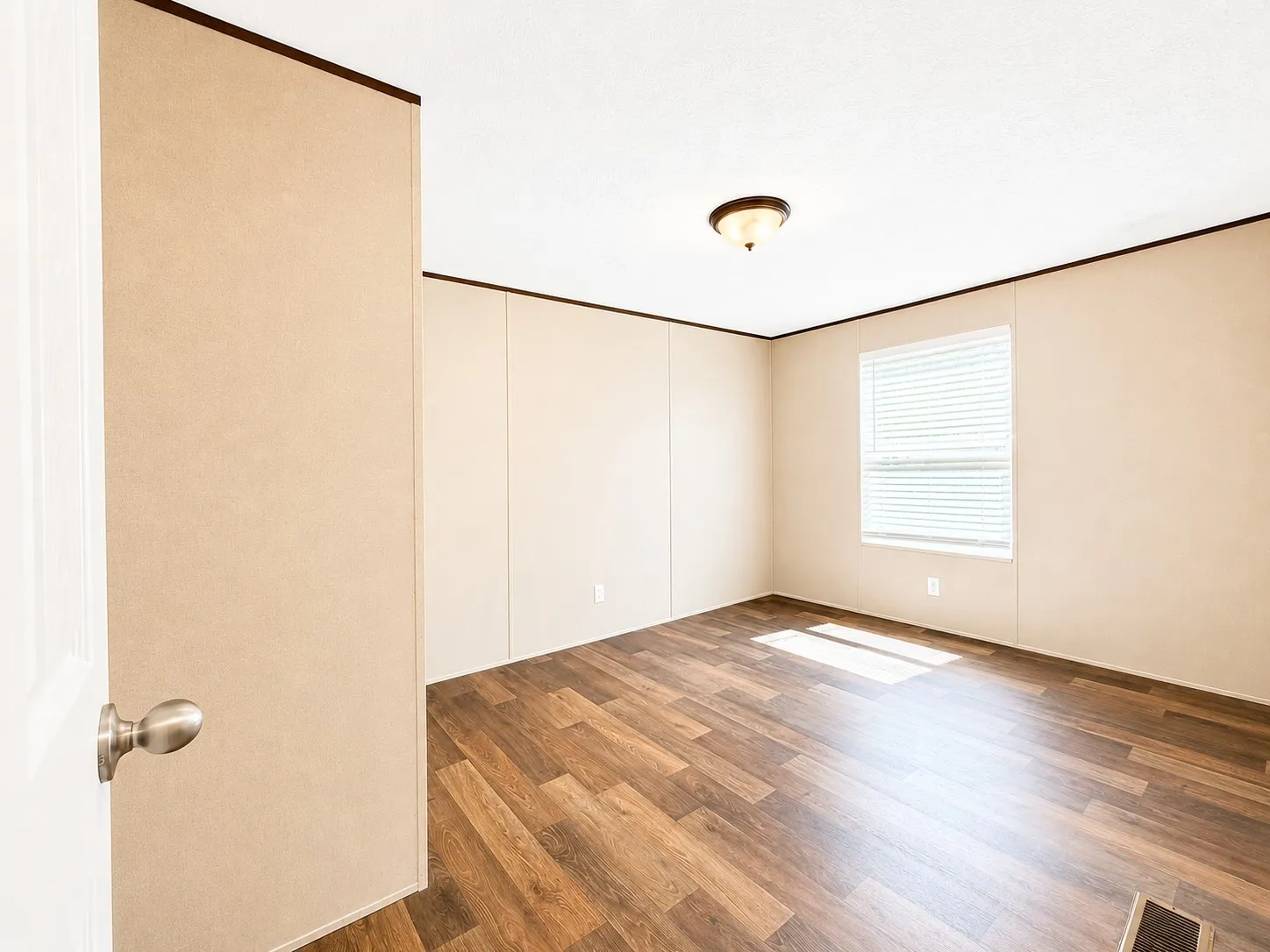 Room featuring wood-finish flooring, a single window with blinds, and a flush-mount ceiling light fixture