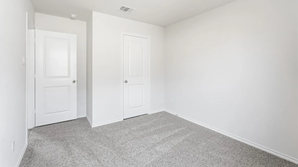 Neutral-toned room with light gray carpet, white baseboards, and white walls