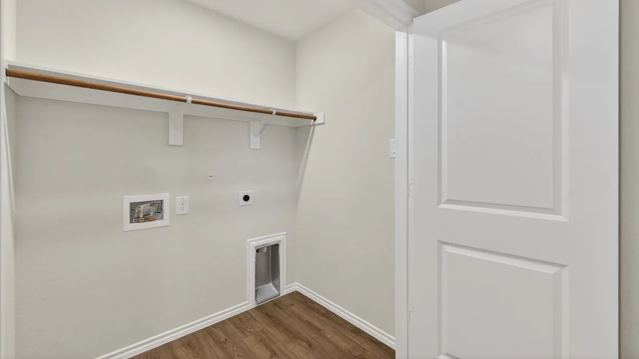 Dedicated utility space featuring wood-finish flooring, light neutral wall paint, and white baseboards