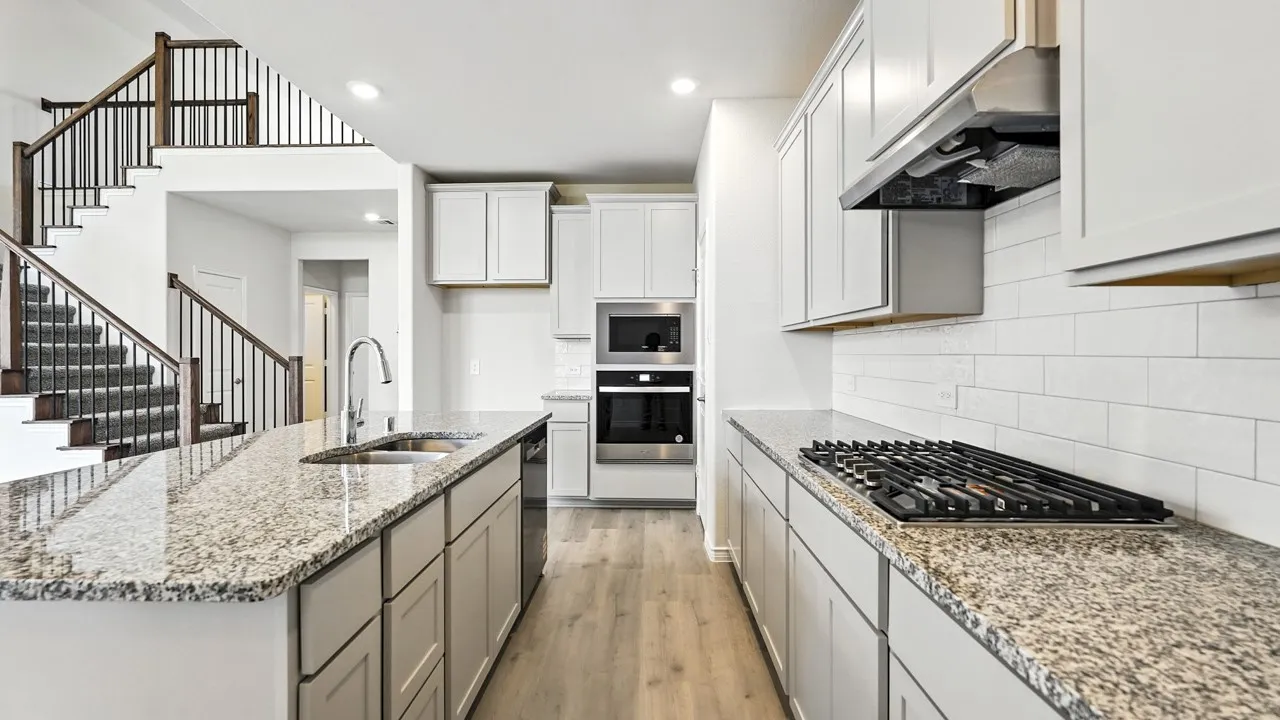 Kitchen featuring an expansive island with a stainless steel sink and granite countertops