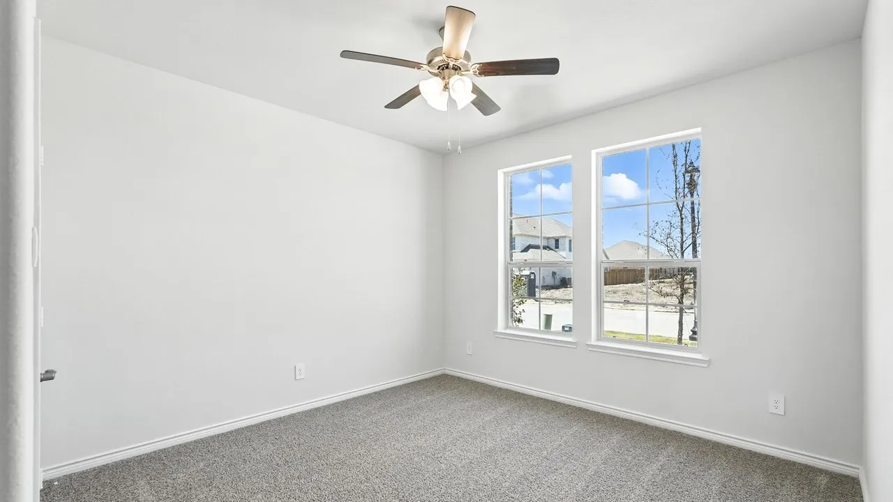 Bedroom featuring neutral carpet flooring, white walls, and a ceiling fan with light fixture