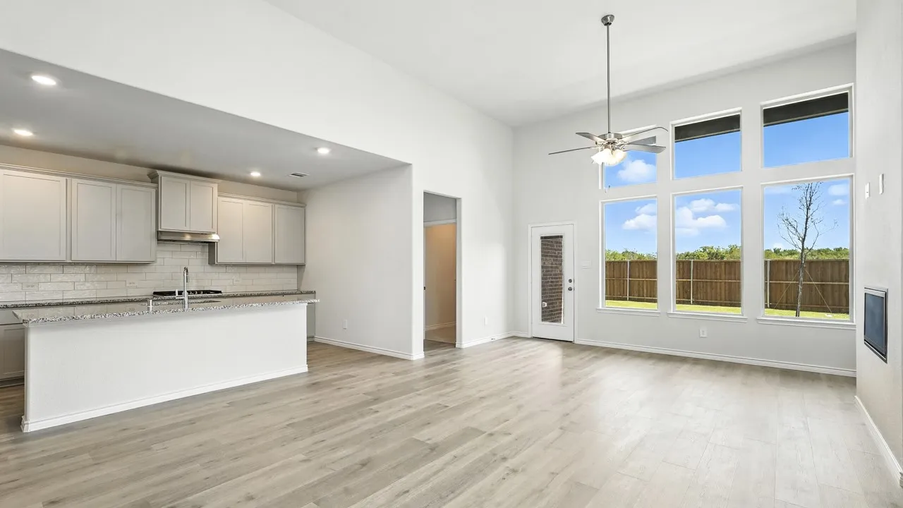 Open-concept living space featuring a soaring ceiling, wood-finish flooring, a contemporary ceiling fan, and a wall of windows