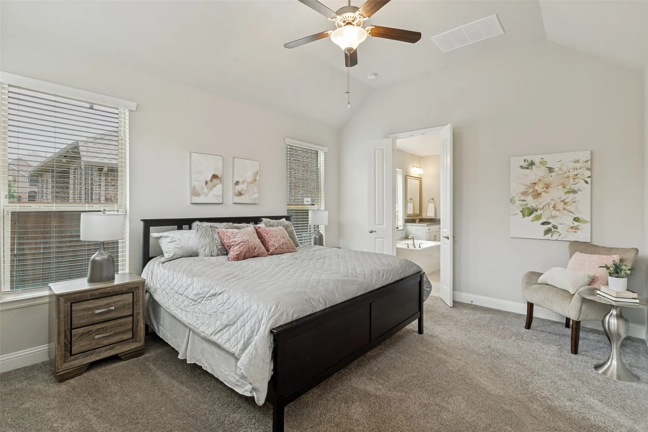 Carpeted room with a vaulted ceiling and ceiling fan