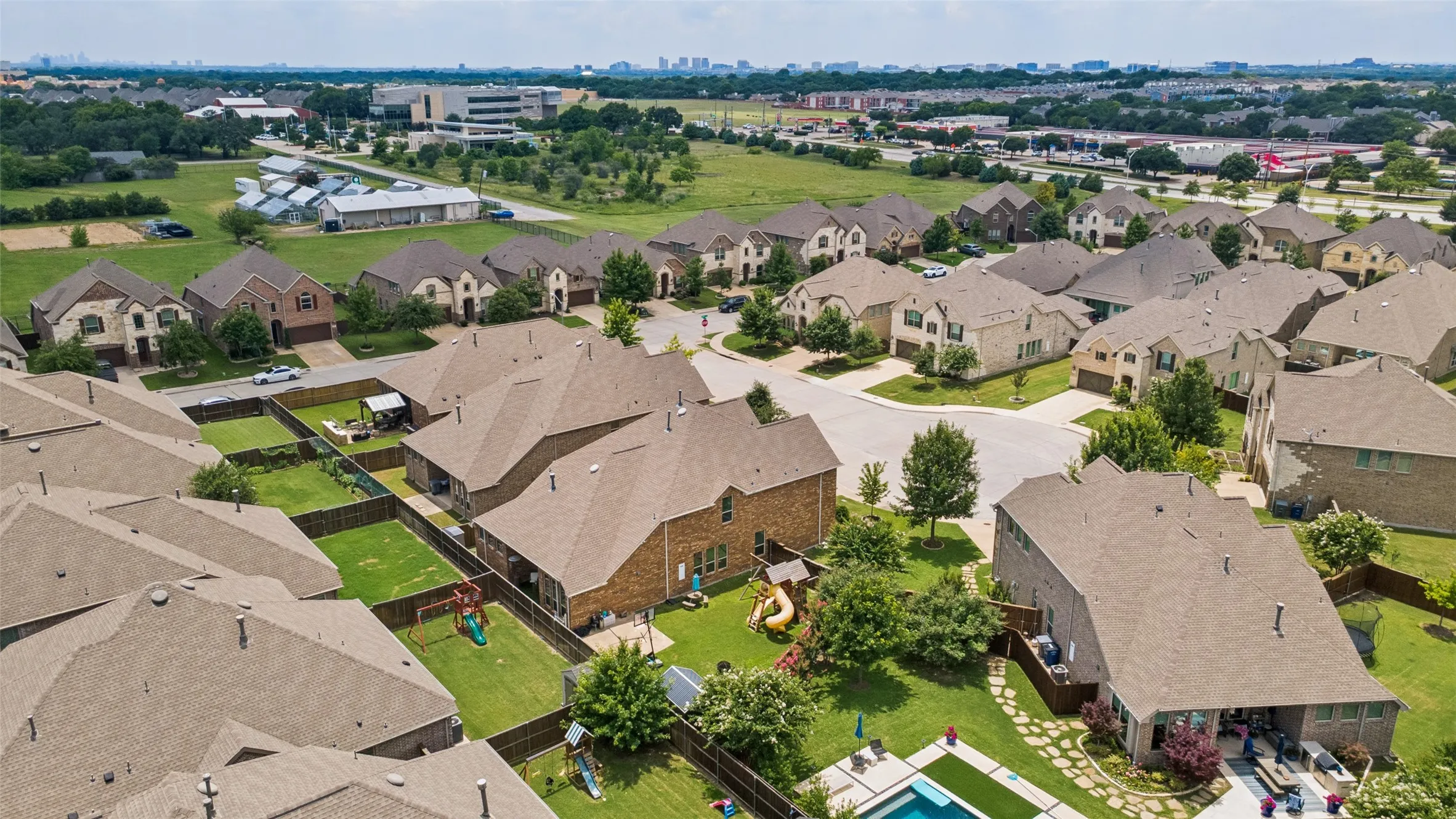 Aerial perspective showcasing a residential community with diverse single-family homes, private fenced yards, and a structured street layout