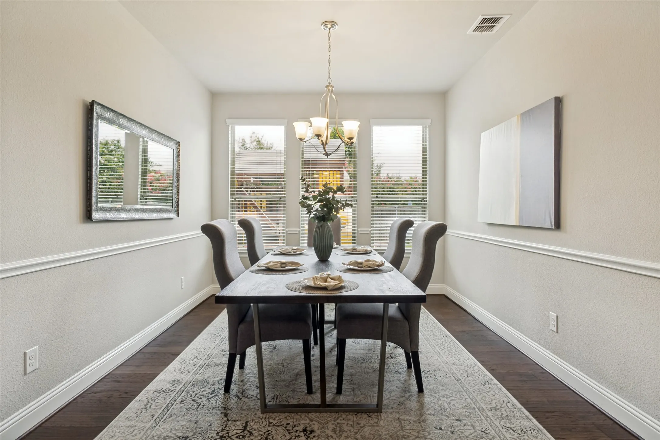 Dining area featuring dark wood-finish flooring, white baseboards, and chair rail molding