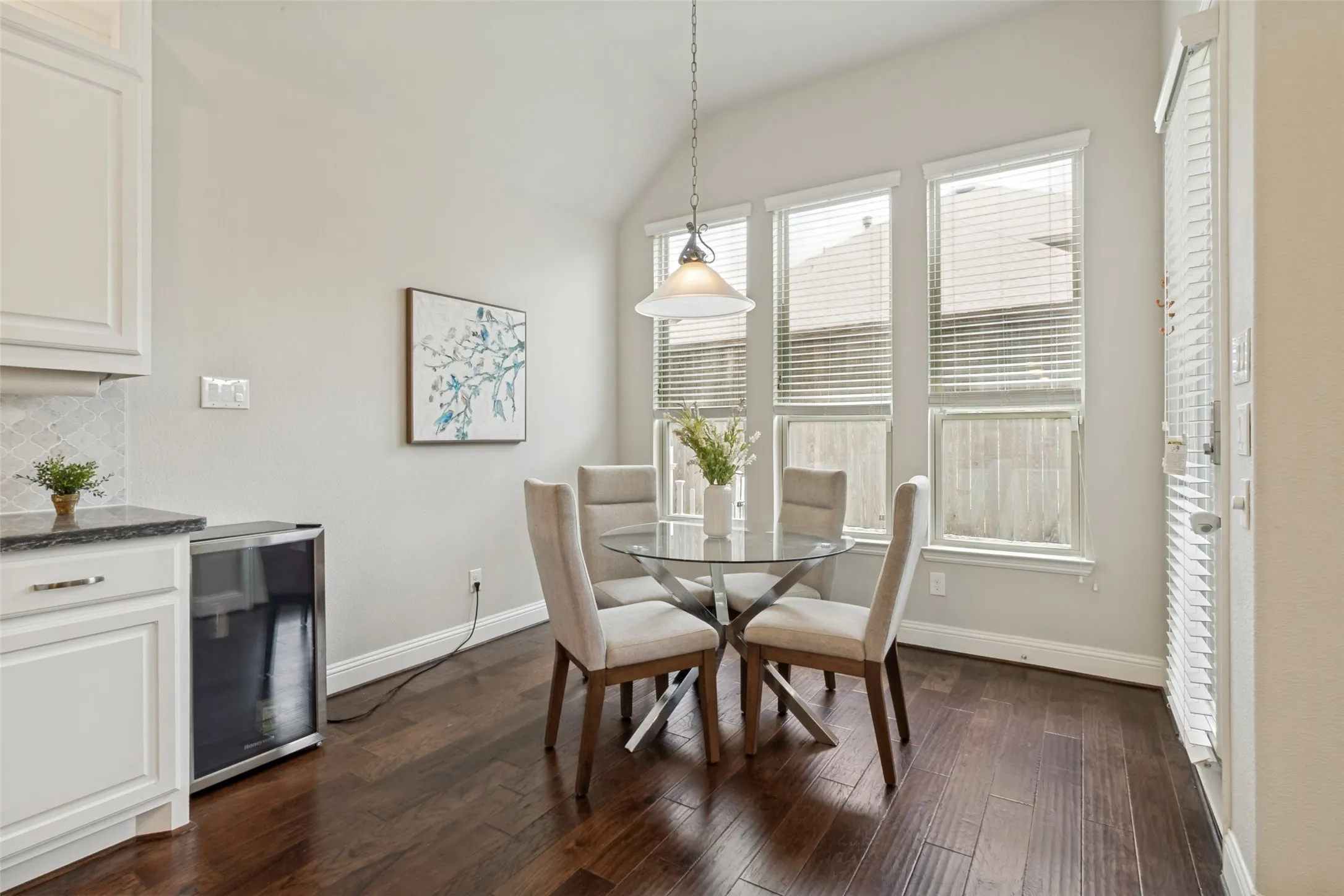 Dining area with vaulted ceiling and wood-finish flooring