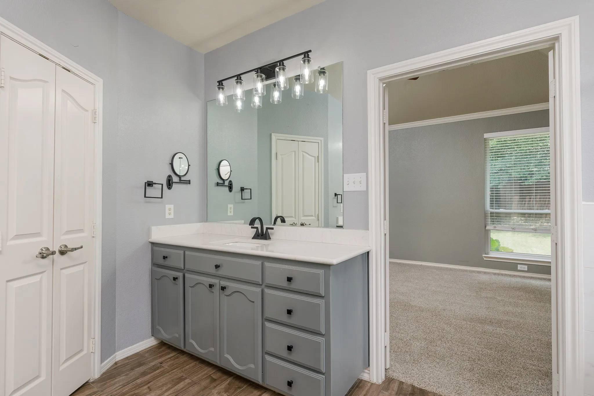 Vanity featuring a white countertop, undermount sink, and black faucet