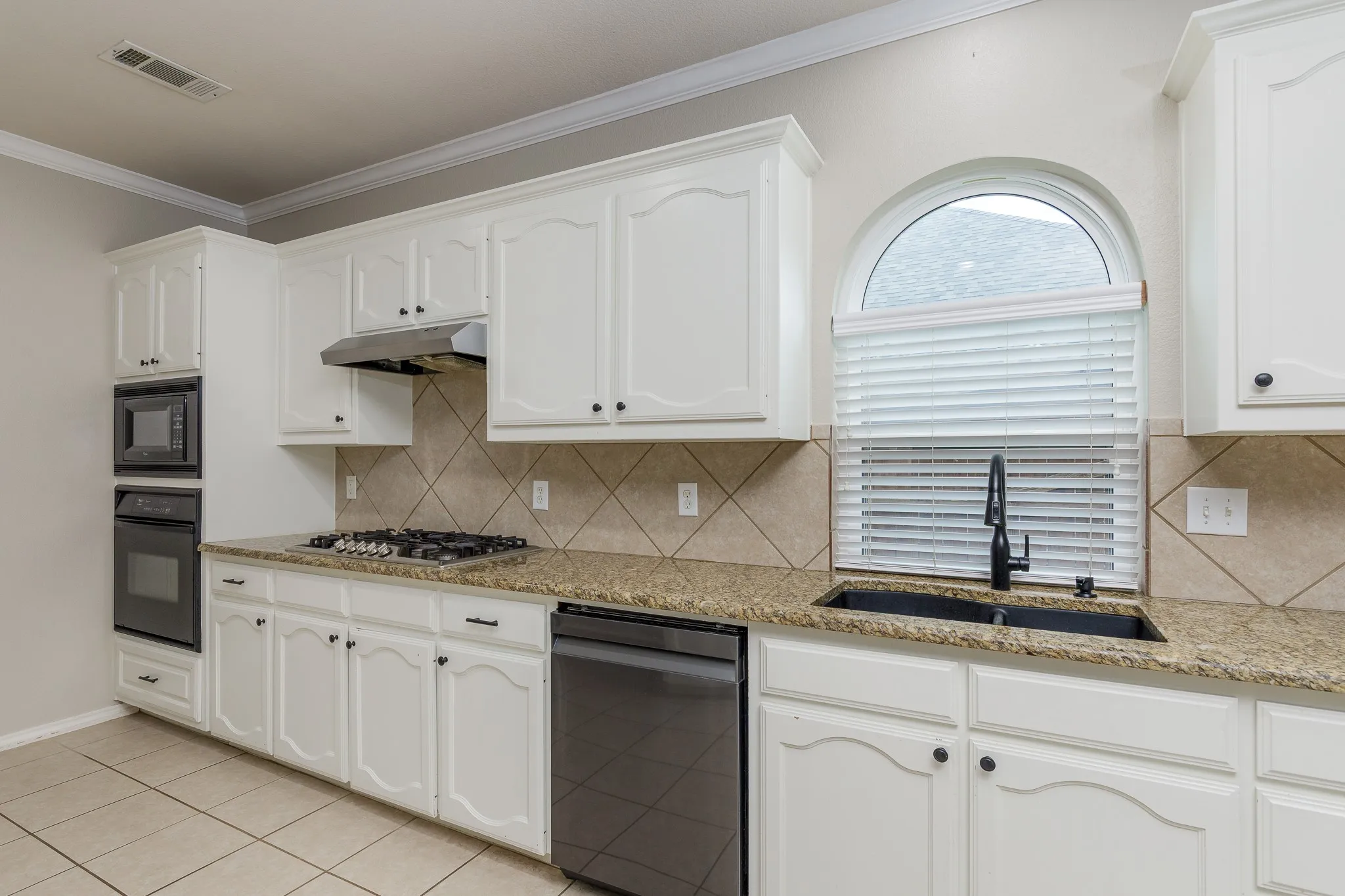 Kitchen featuring white cabinetry, light-toned granite countertops, and a full suite of stainless steel appliances