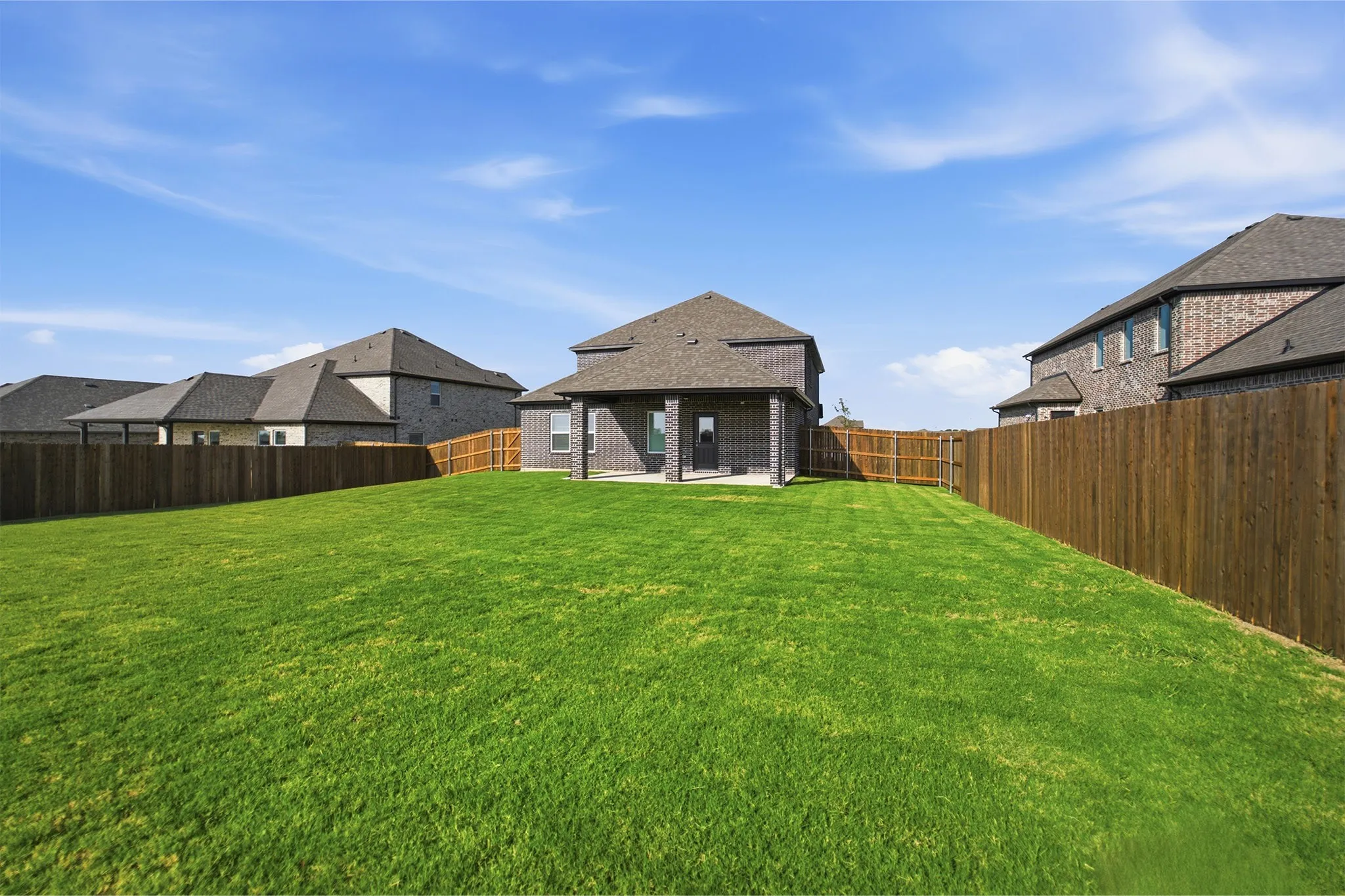 Expansive green lawn with a wood privacy fence