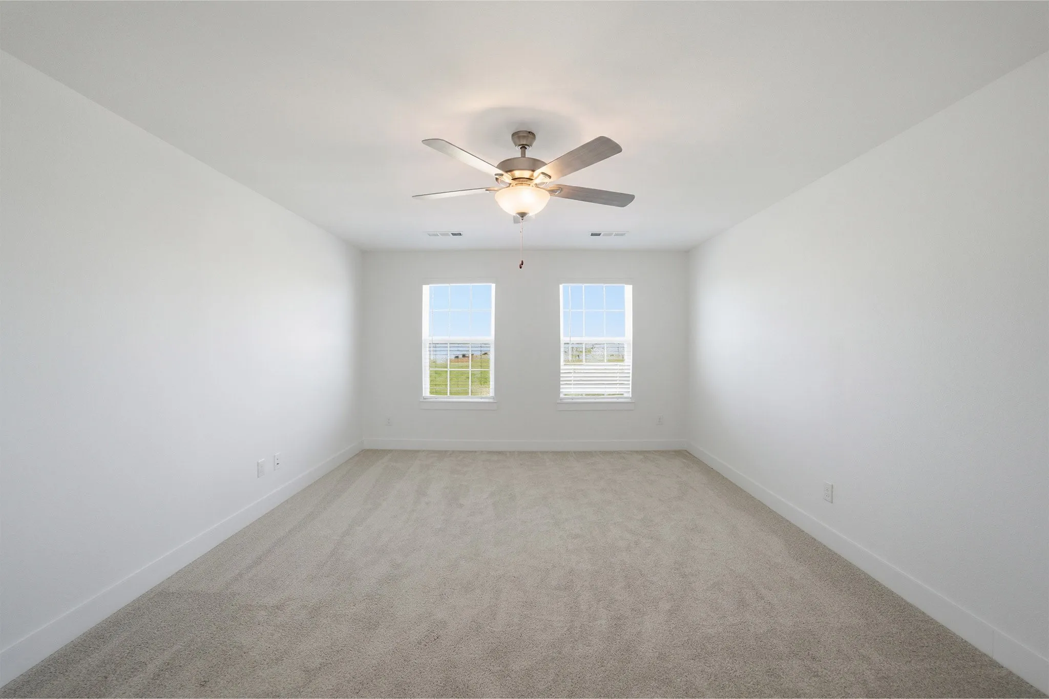 Carpeted room with a ceiling fan light fixture