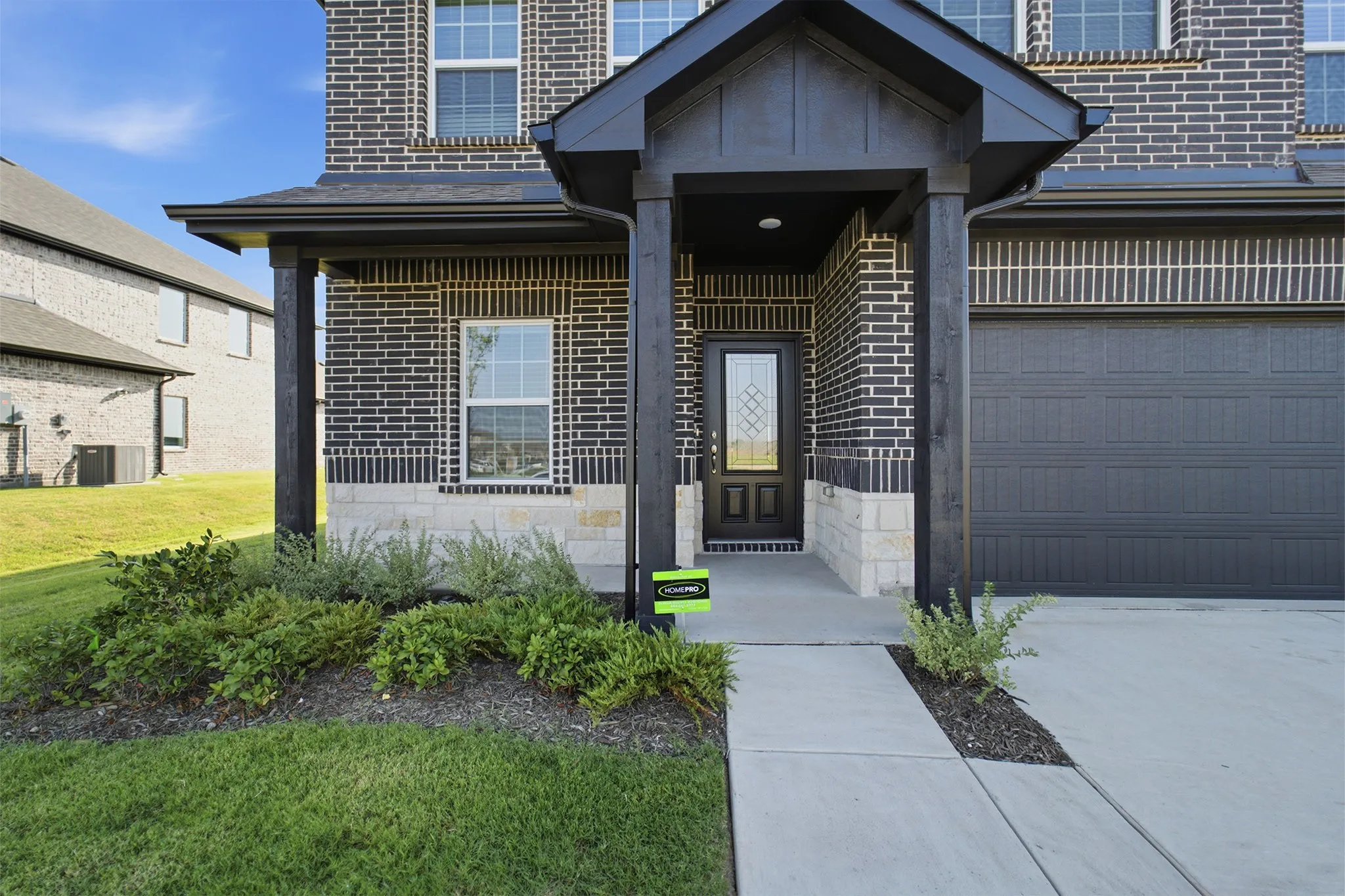 Two-story exterior with dark brick and stone accents