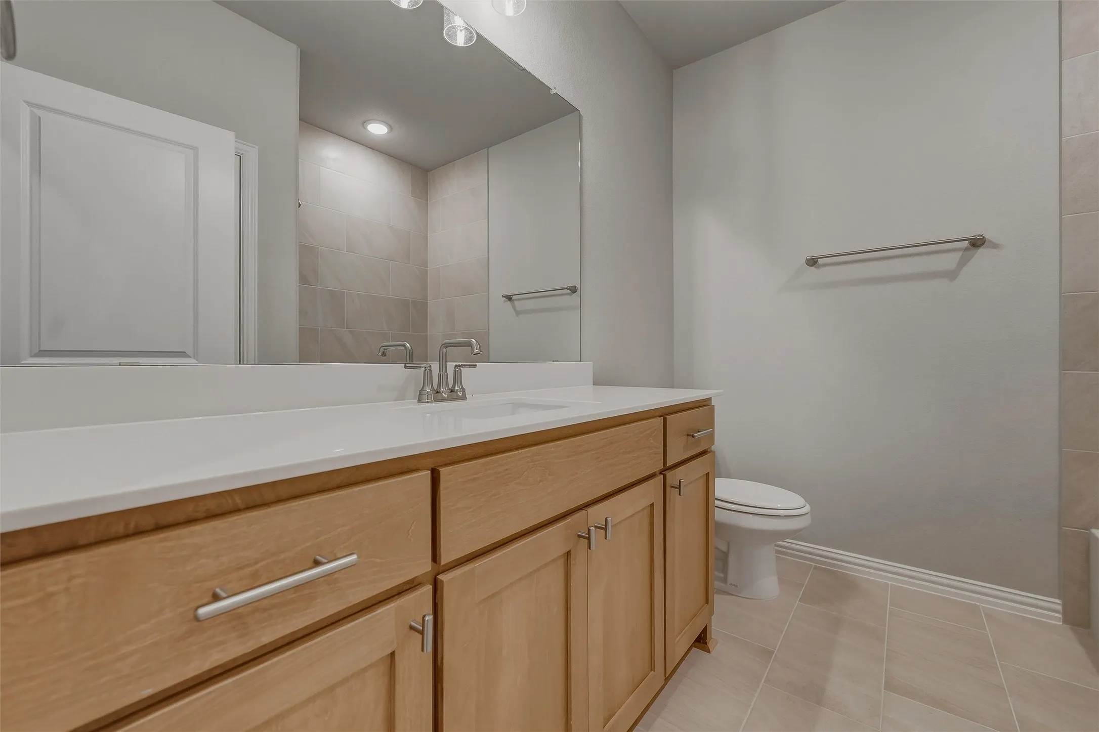 Wood-finish vanity with a white countertop and brushed nickel hardware
