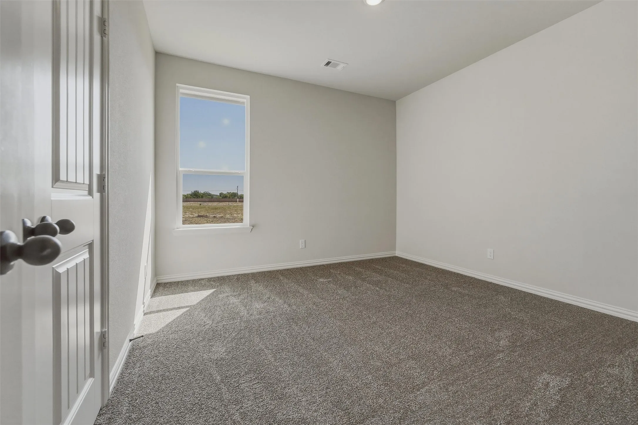 Neutral wall paint with textured carpet flooring