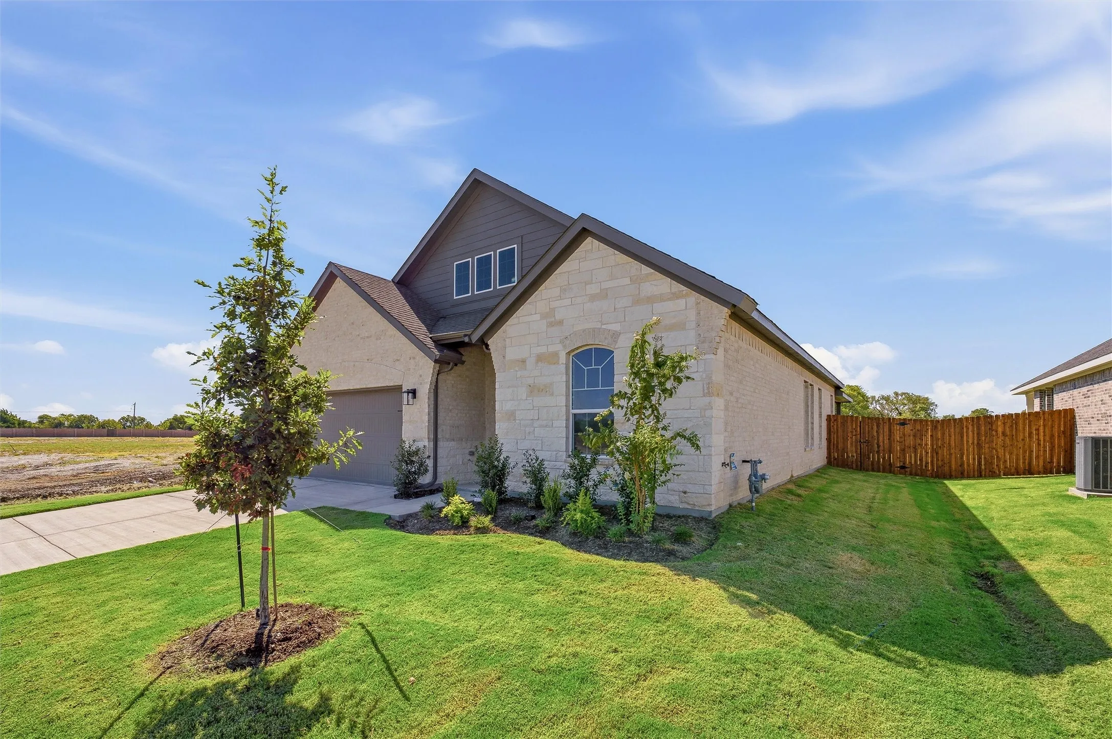 Stone and siding exterior with an arched window accent