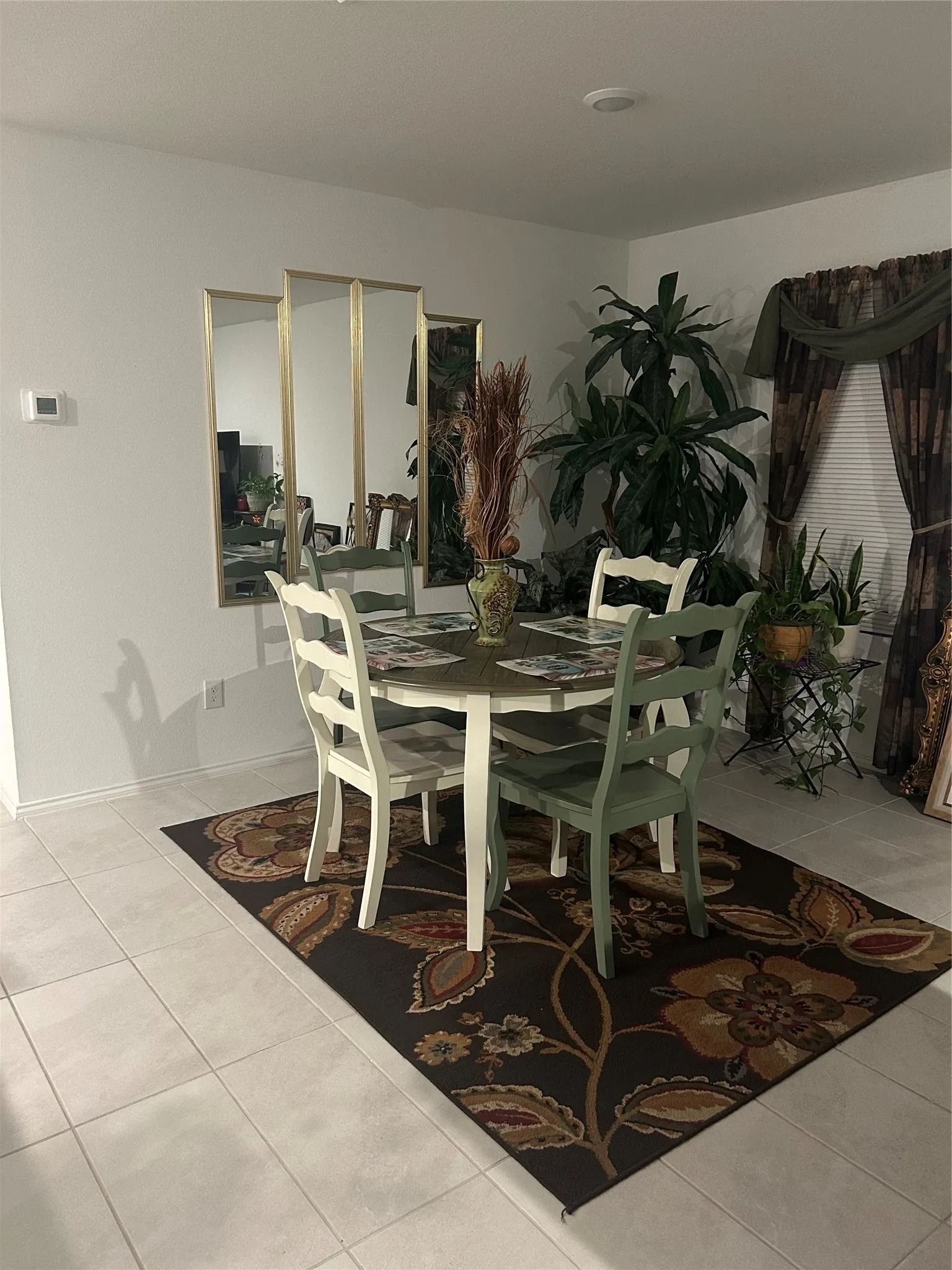 Dining area featuring light-toned tile flooring and a ceiling-mounted light fixture