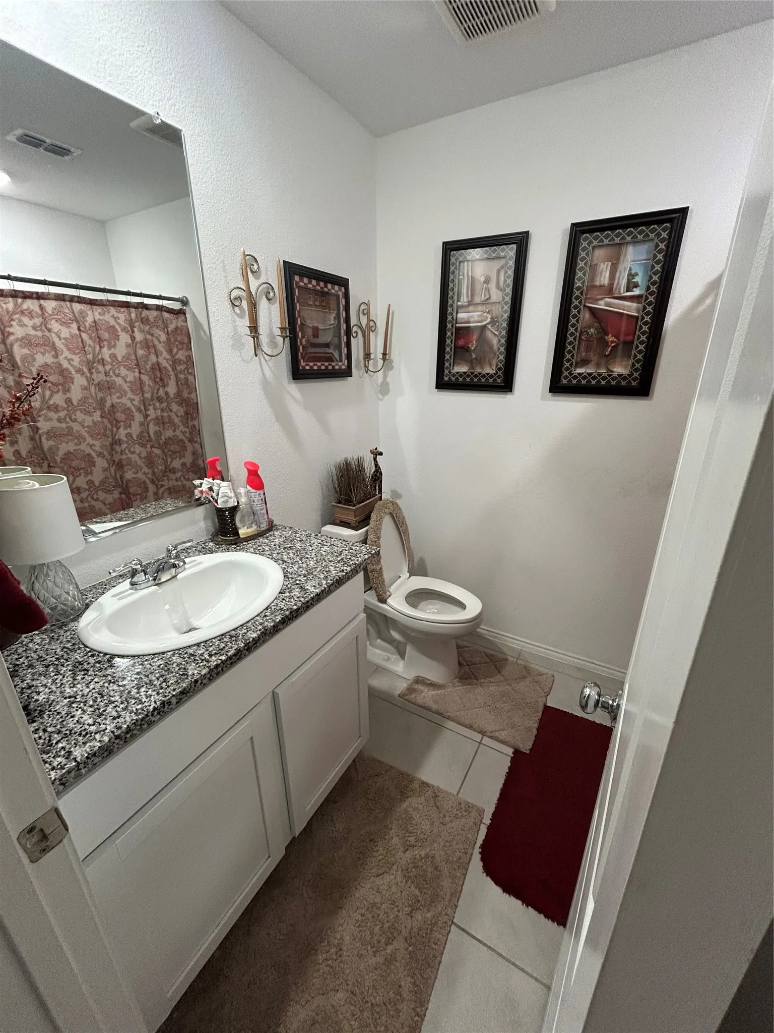 Bathroom vanity with a granite-style countertop, undermount sink, and chrome fixtures