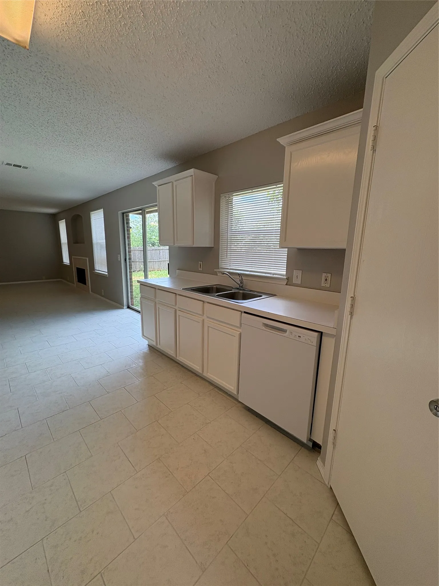 Kitchen featuring white cabinetry, light countertops, and tile flooring