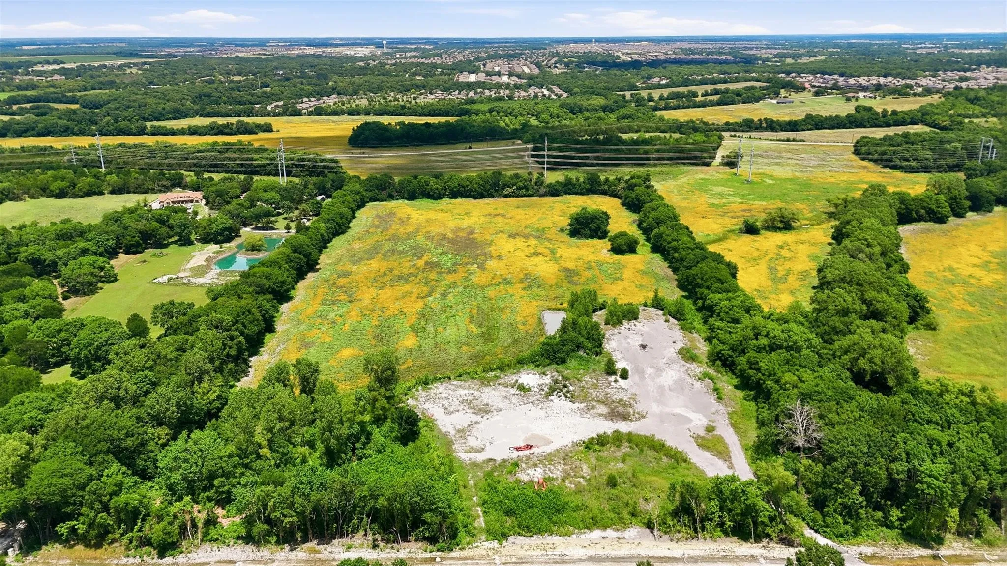 Expansive undeveloped acreage featuring a mix of open fields and mature tree lines