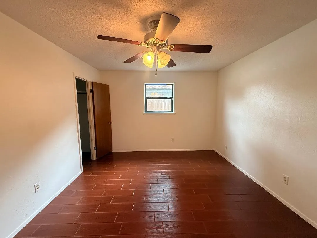 Warm-toned tile flooring complements neutral wall tones and white baseboards