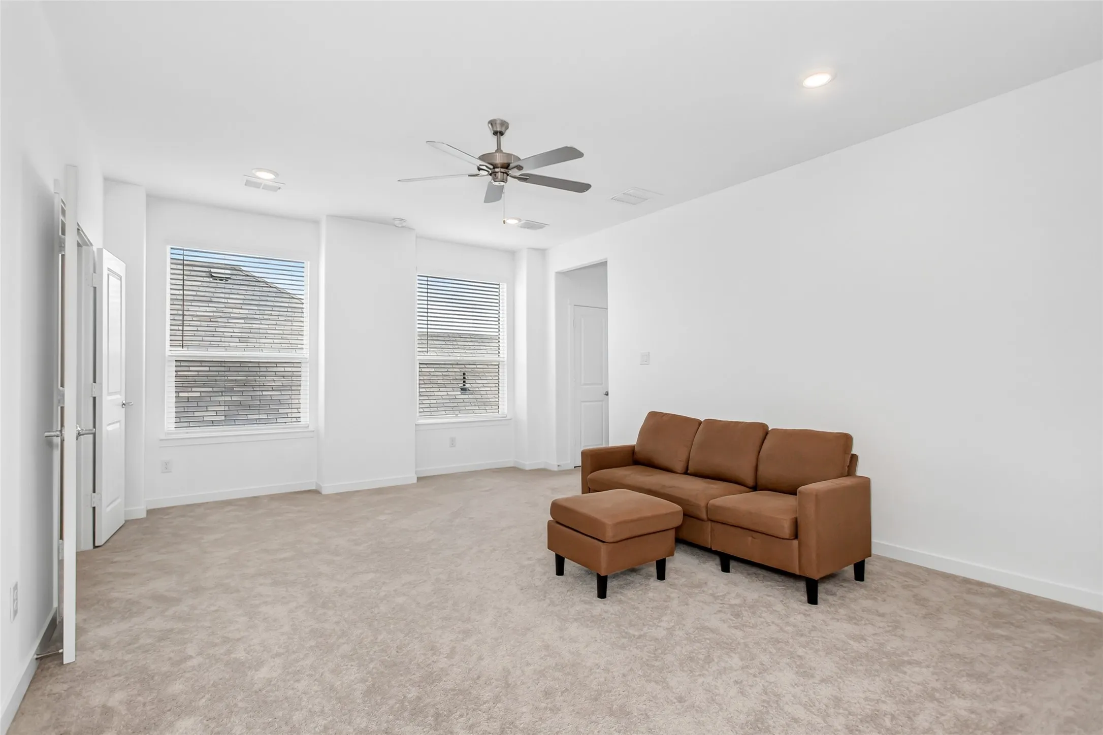 Spacious room with light-toned carpeting and white walls