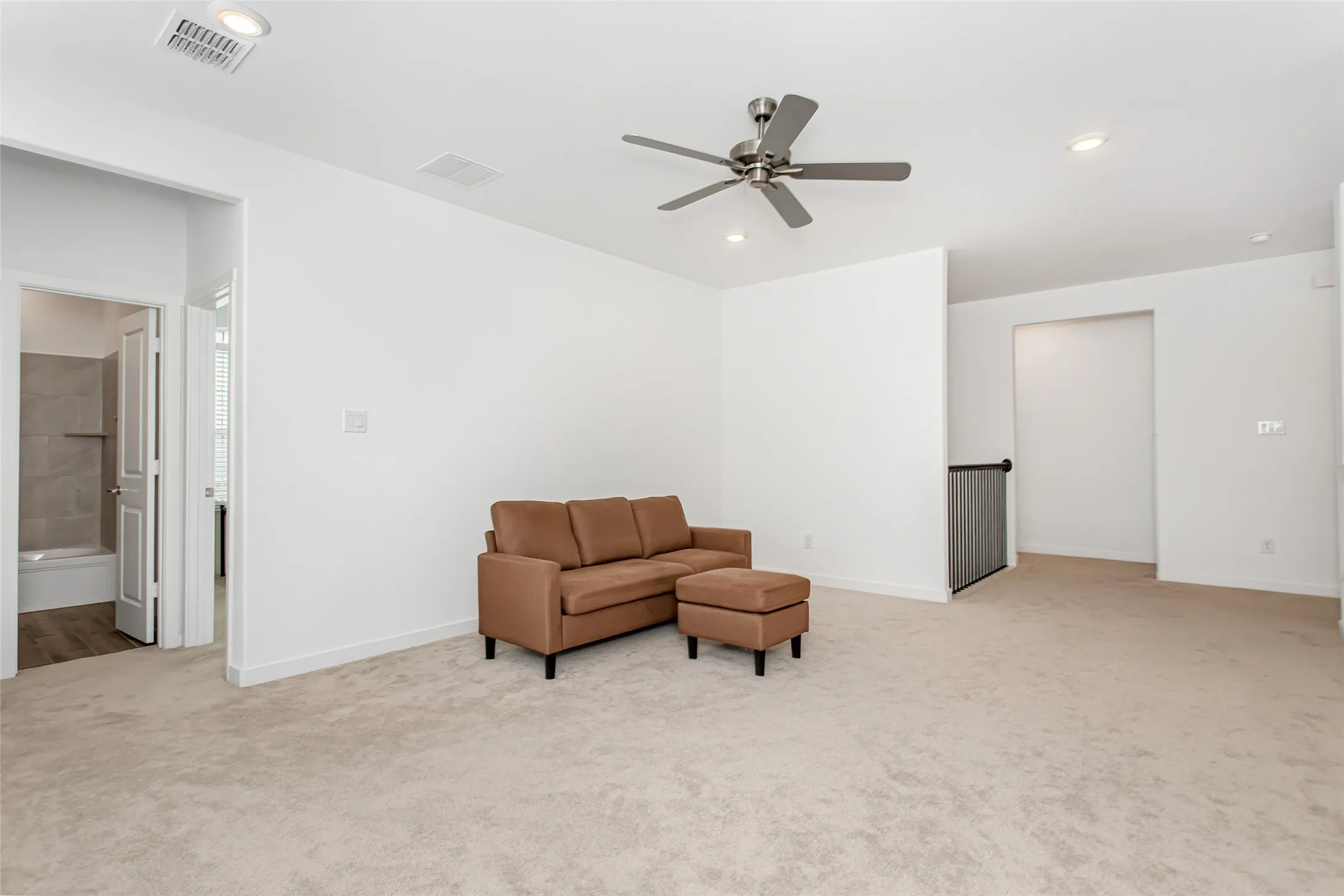 Carpeted upper-level living area featuring recessed lighting, a ceiling fan, and crisp white walls