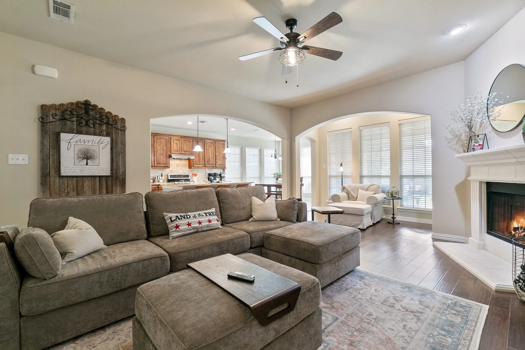 An open and spacious living room that is the center of the home featuring a decorative gas fireplace.