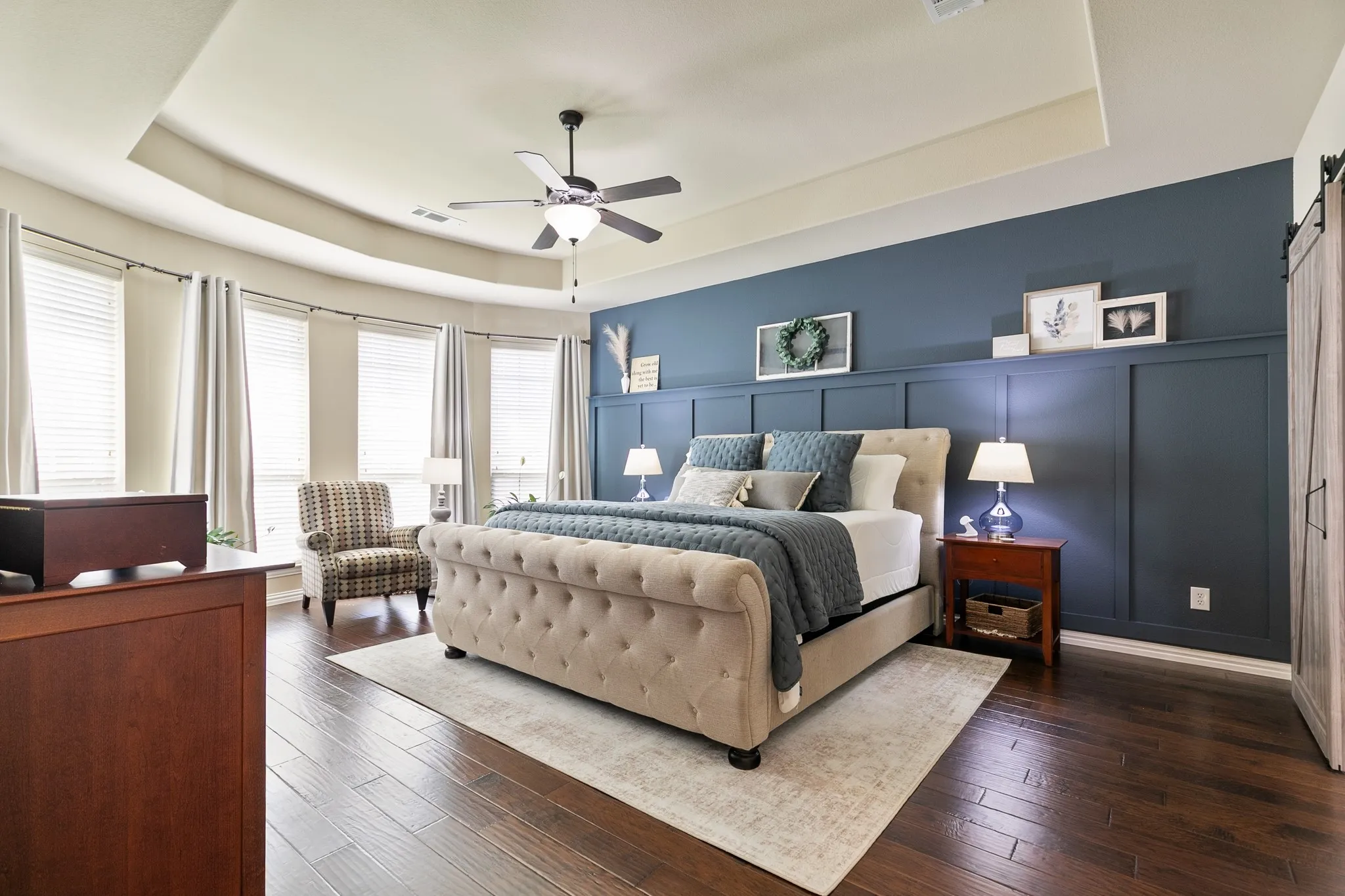 Oversized primary bedroom with floor to ceiling windows offering an abundance of natural light.