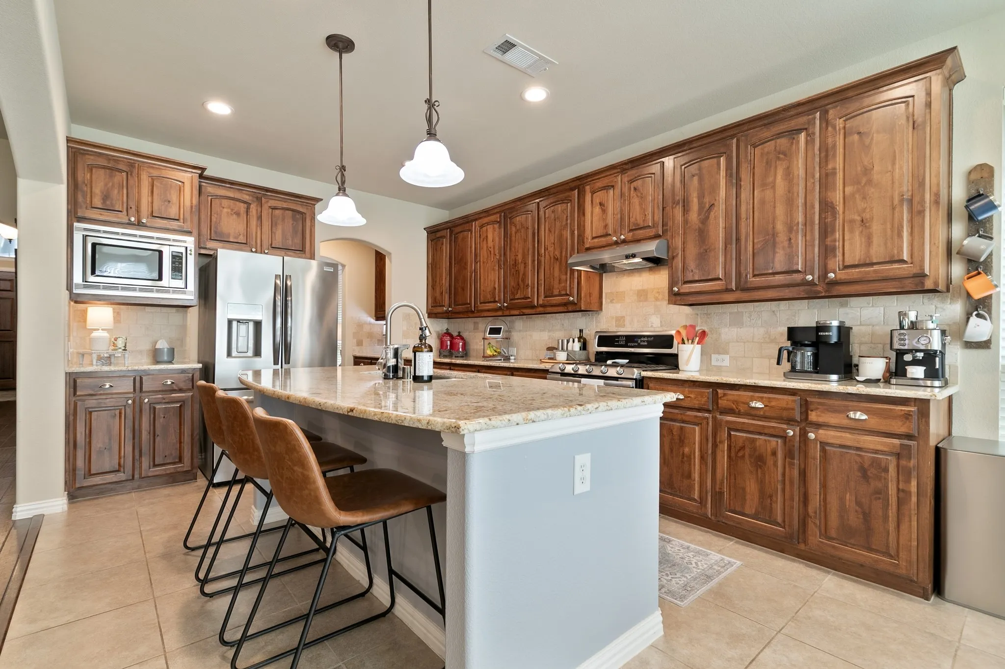 An abundance of cabinetry, breakfast bar and stainless-steel appliances.