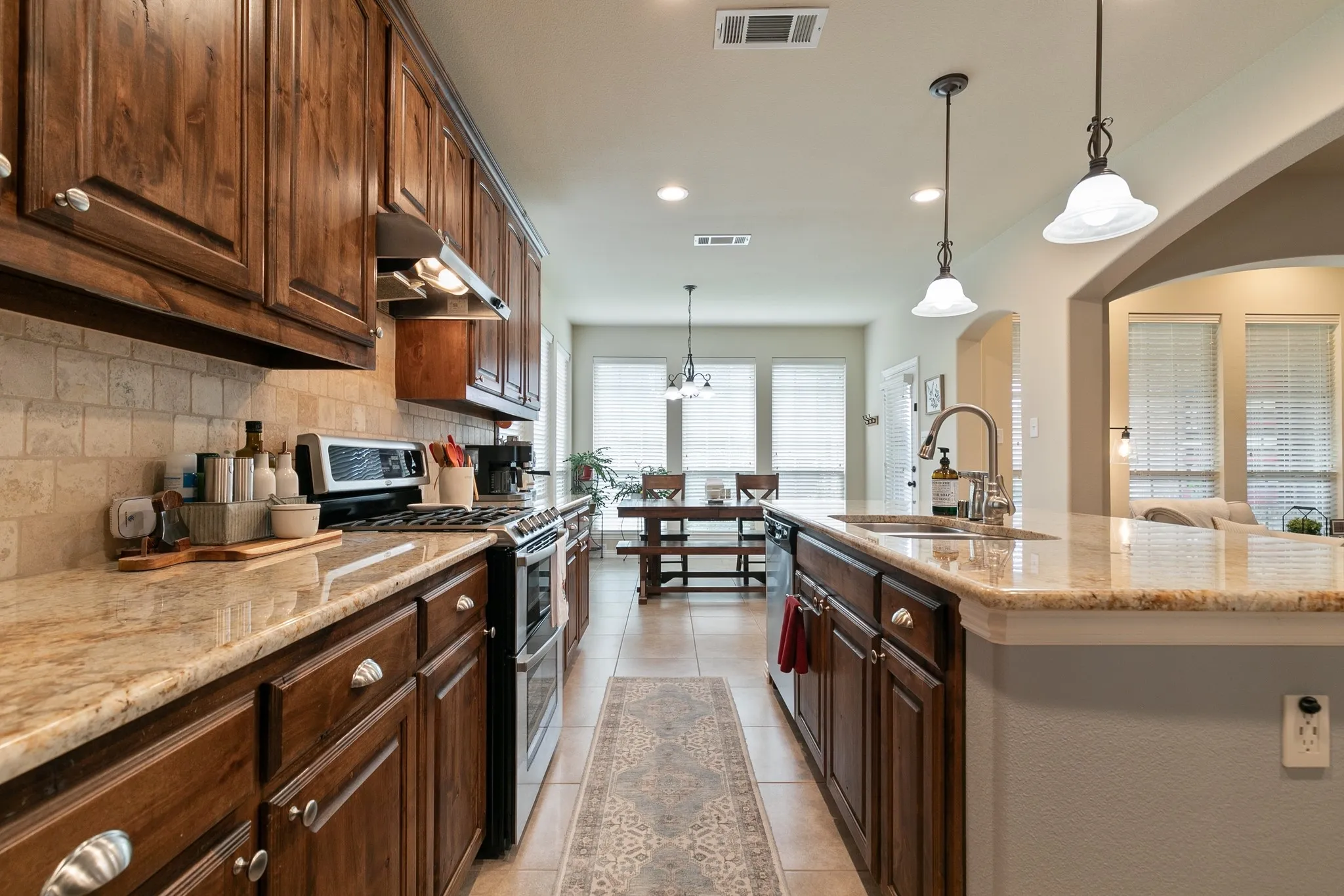 Spacious kitchen with a large island, granite countertops, decorative backsplash and gorgeous oak cabinetry.