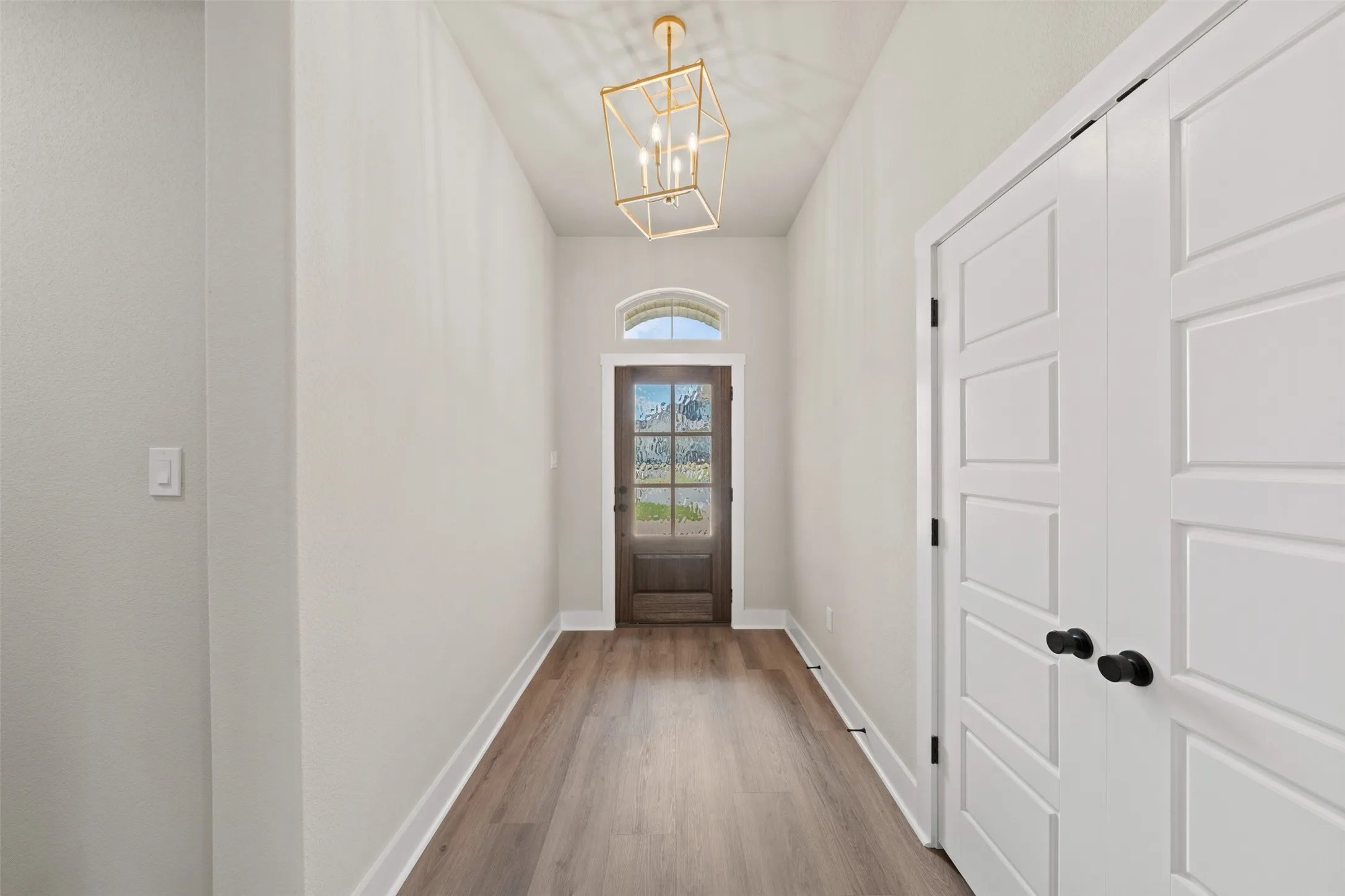 Entryway with wood-finish flooring, white baseboards, and light neutral wall finishes