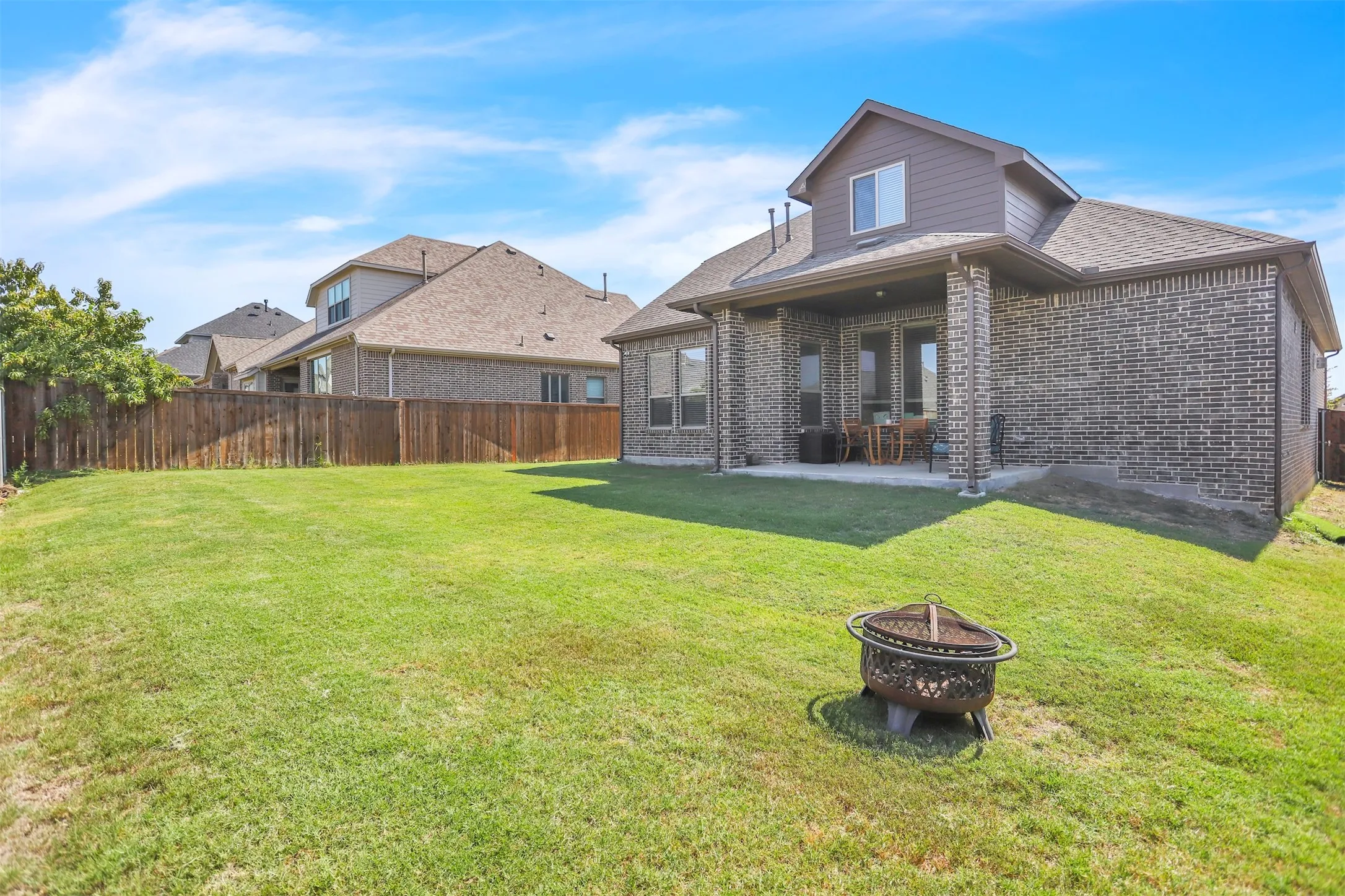 Covered back patio and a large yard for this neighborhood