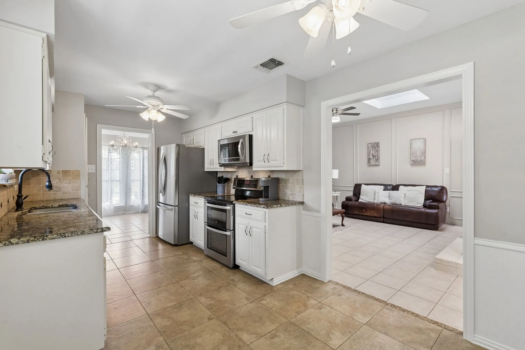 Kitchen with double ovens opens to the living room and dining areas.