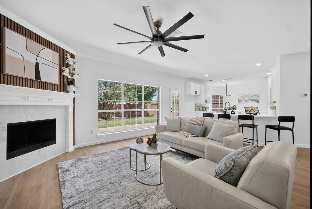 Expansive open-concept living area featuring wood-finish flooring and a contemporary ceiling fan
