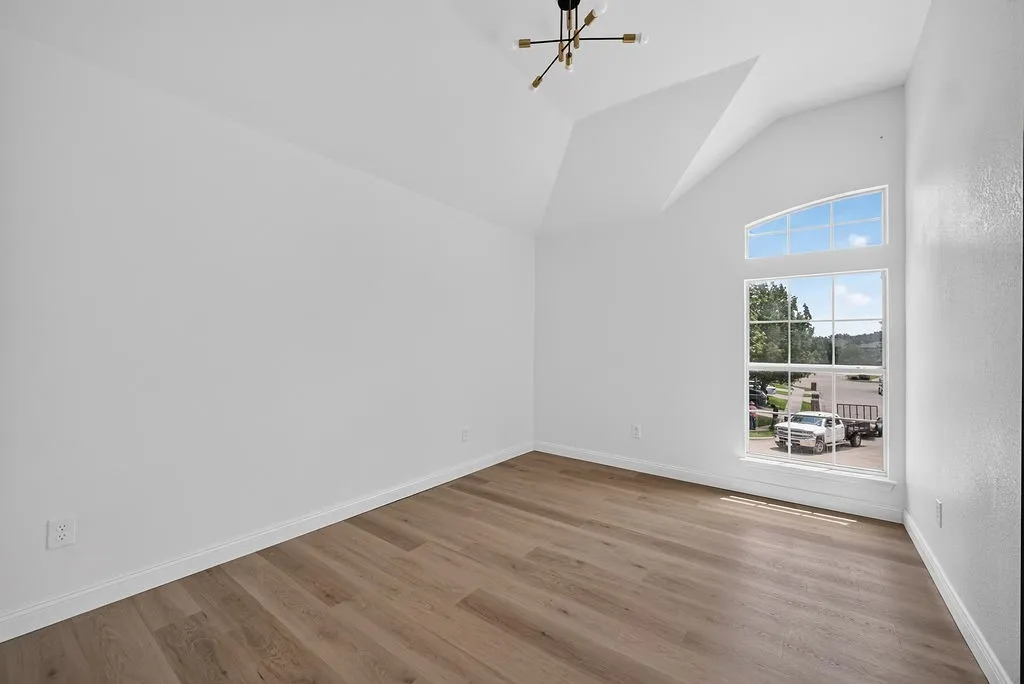 Vaulted ceiling featuring a modern chandelier