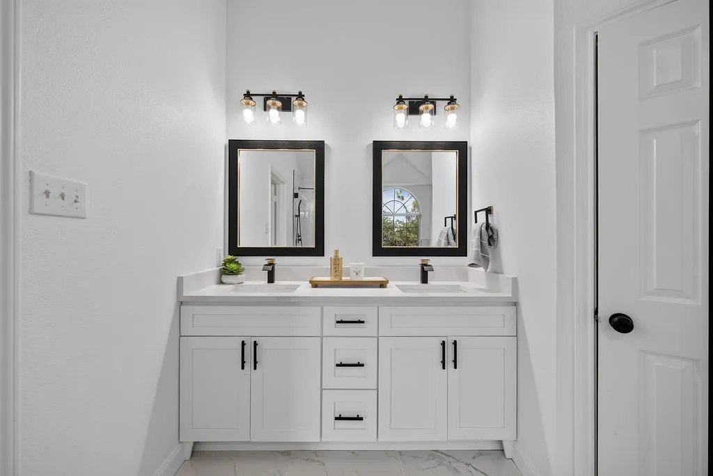 Dual vanity with white cabinetry and black hardware