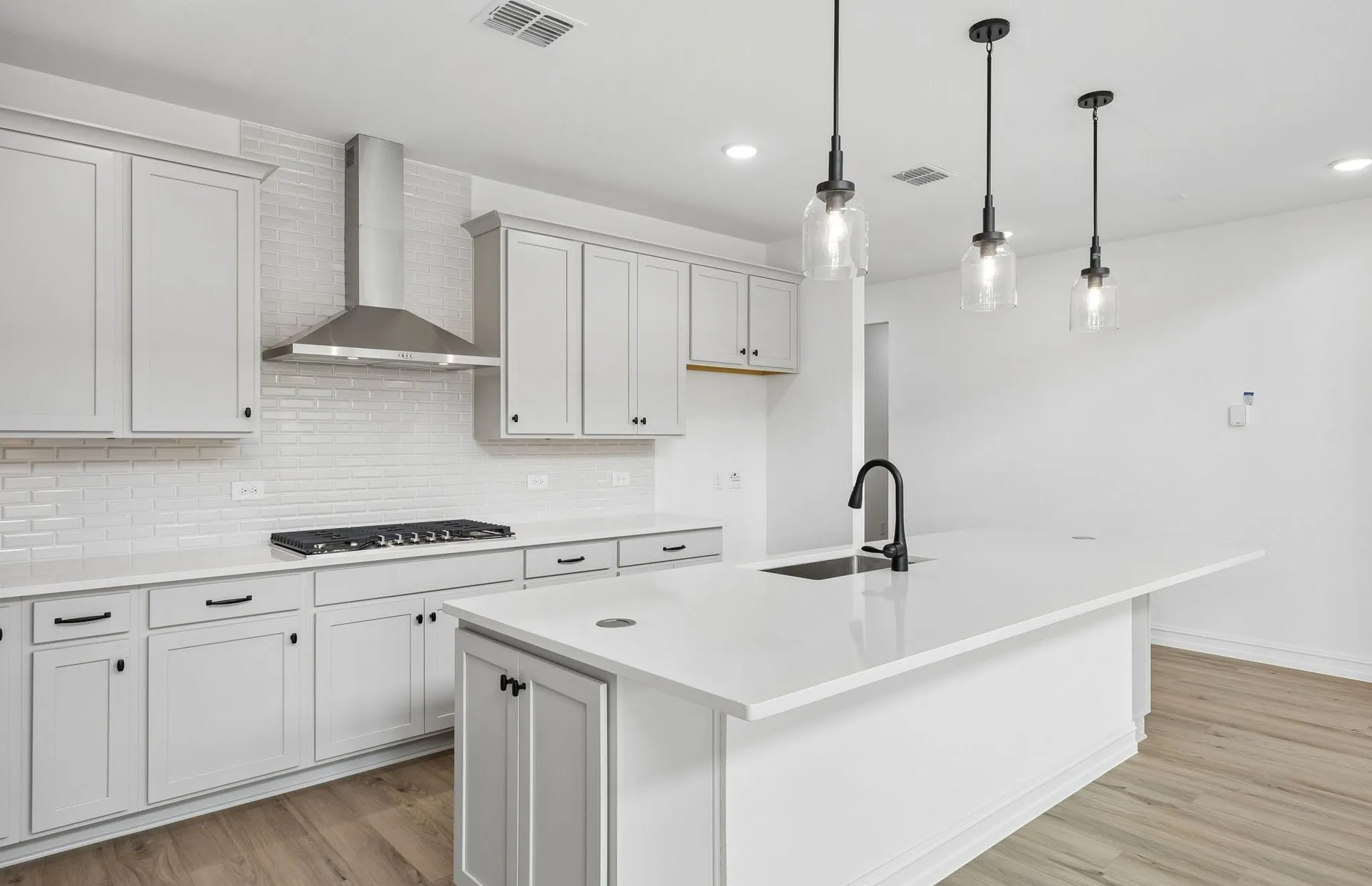 Abundant cabinet space and pendent lighting in kitchen