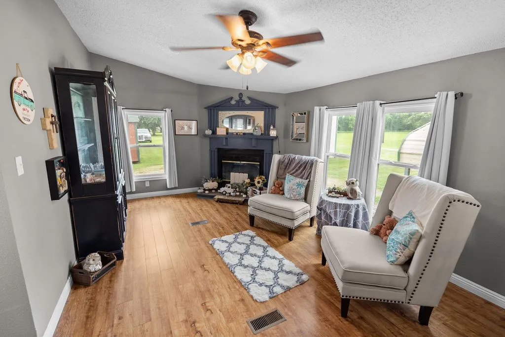 Beyond the dining room is this den/hearth room with wood-burning fireplace, exit to side yard