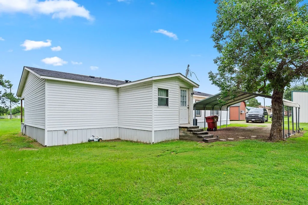 Two car carport behind the home next to the back door