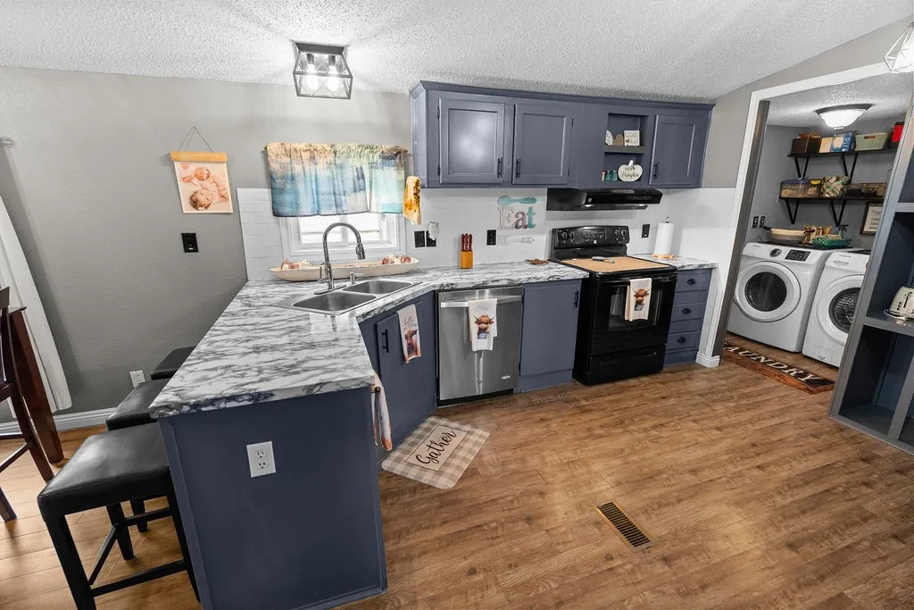 Kitchen has lots of counter space, breakfast bar, updated dishwasher and electric range