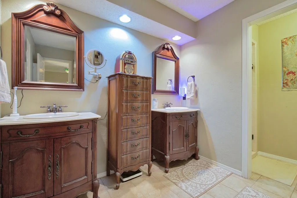 Dual vanity setup featuring wood-finish cabinetry and rectangular undermount sinks