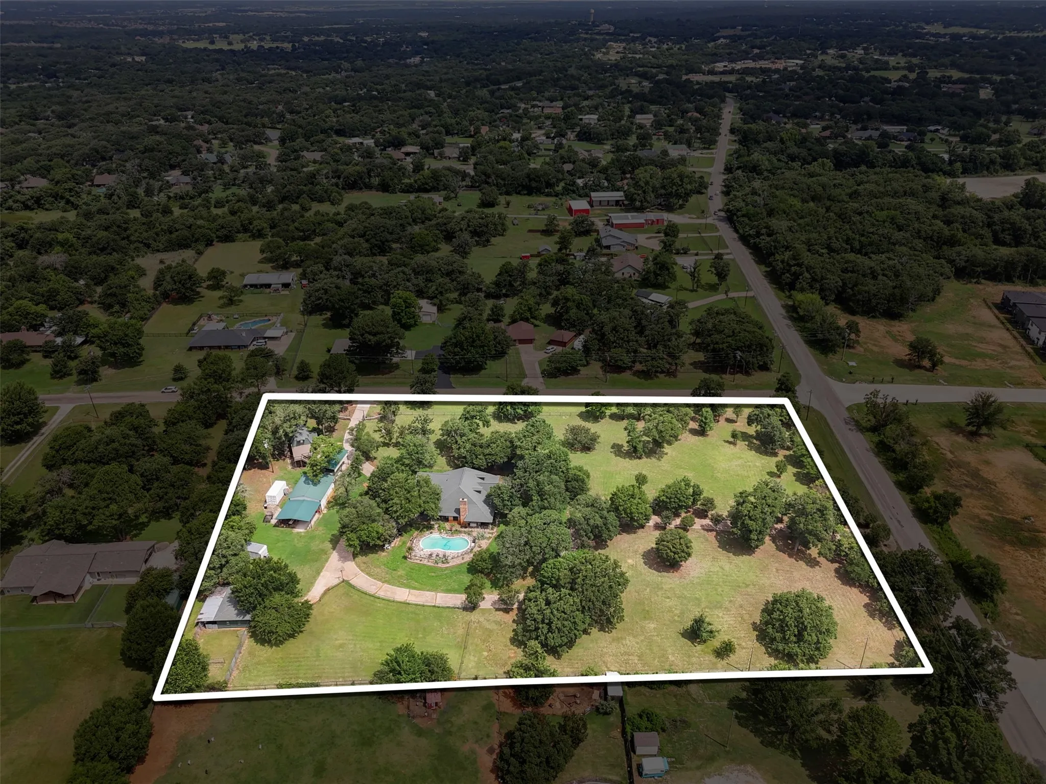 Expansive property featuring mature trees and a manicured lawn