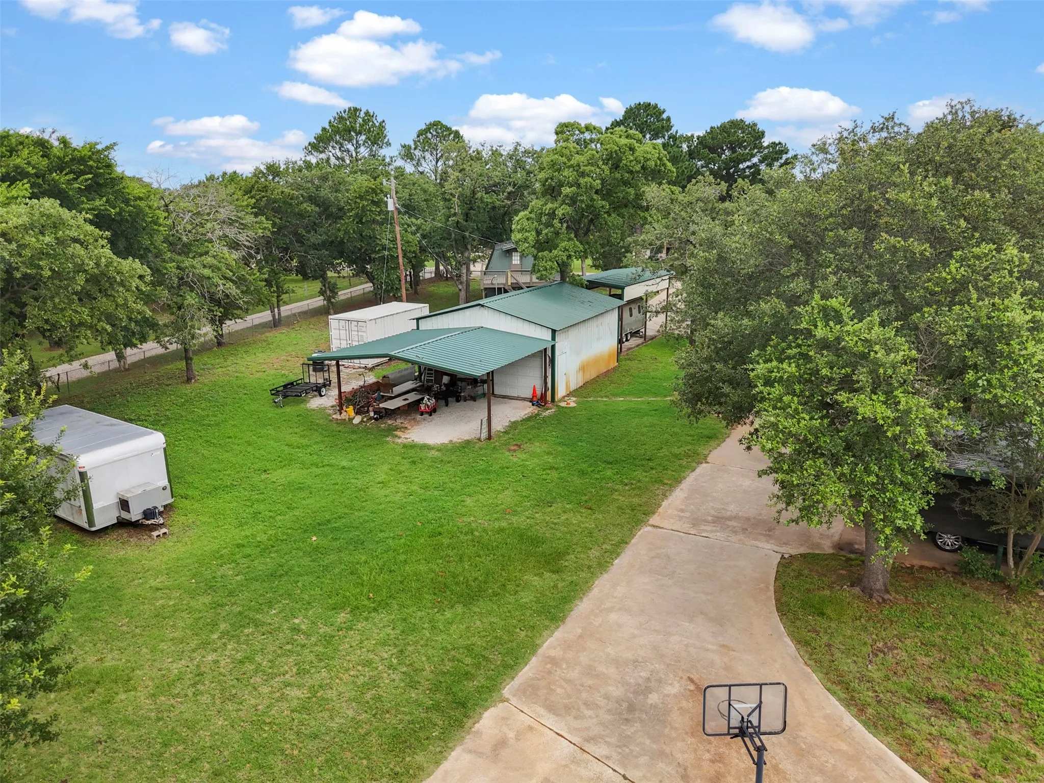 Expansive property featuring a concrete driveway and mature trees