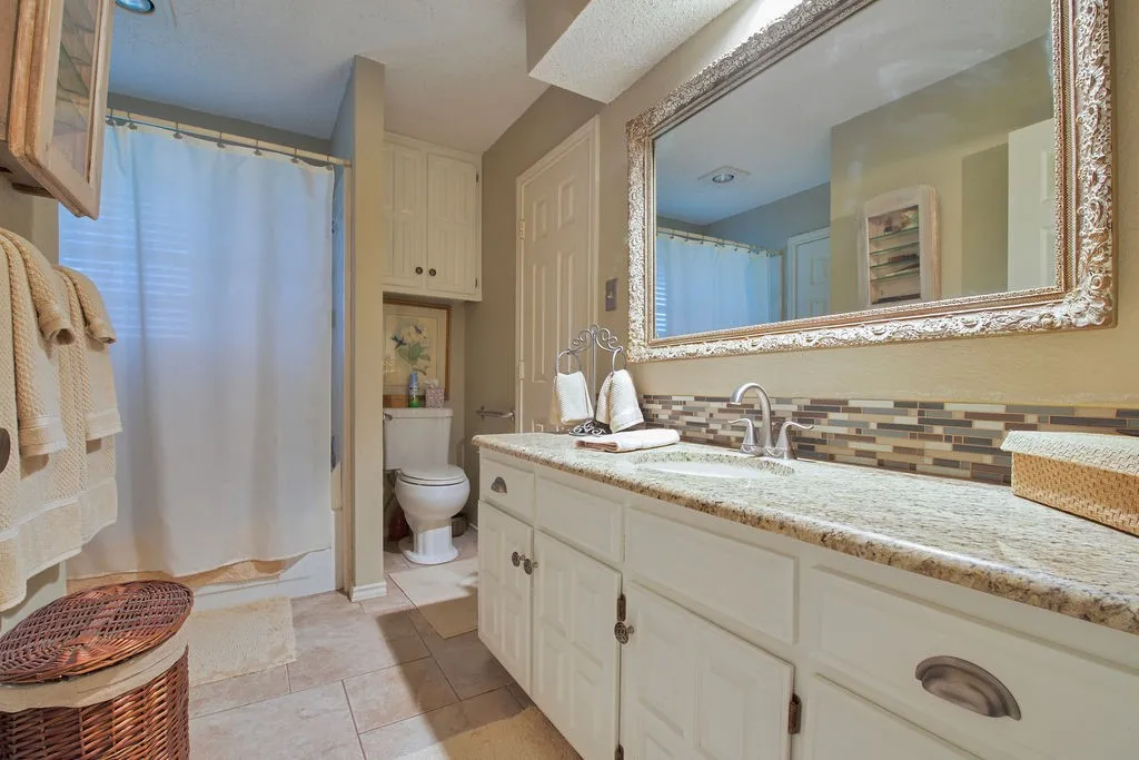 Bathroom featuring a spacious vanity with a light-colored countertop and undermount sink